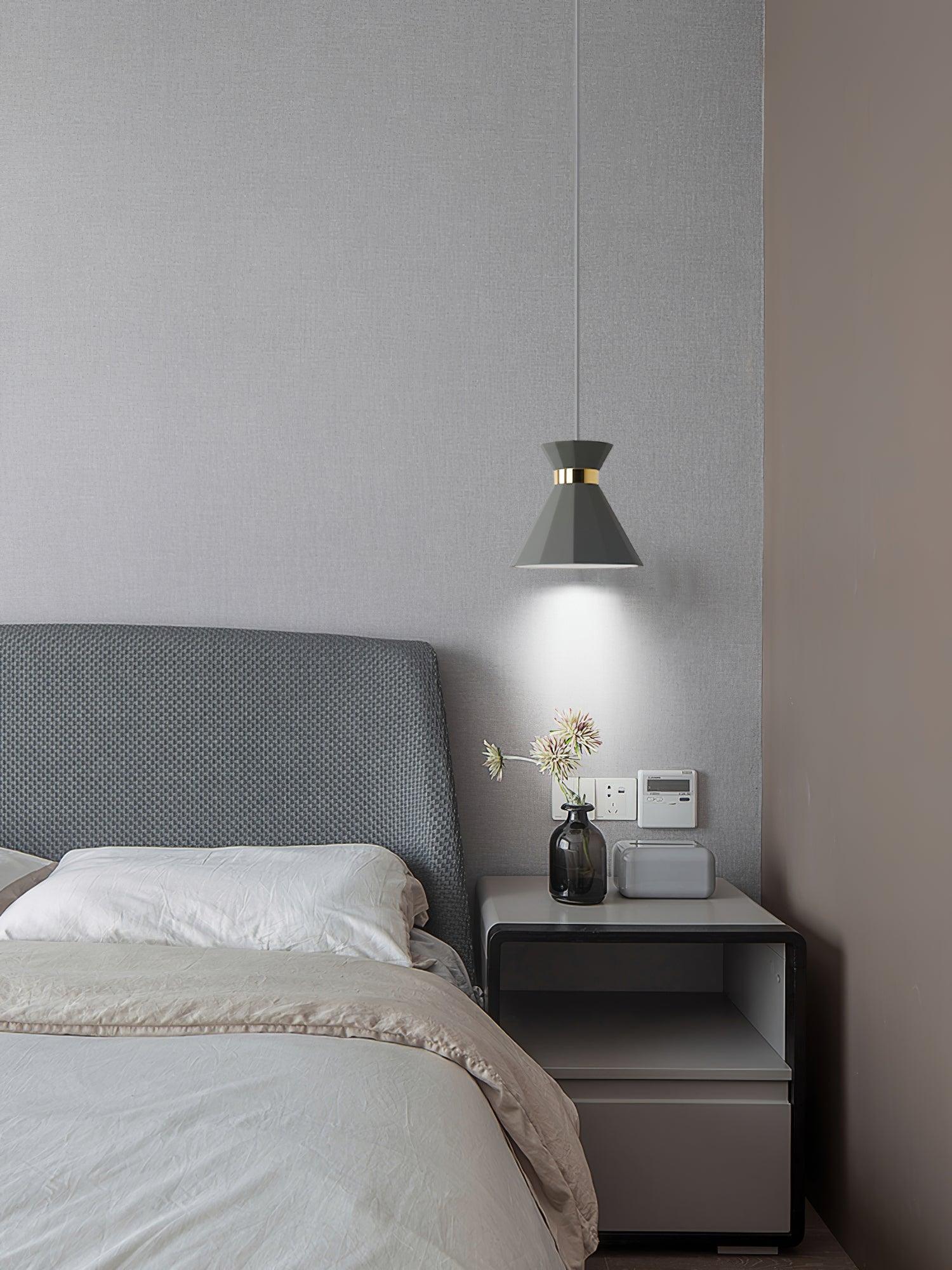 Illuminated grey pendant at a bedside