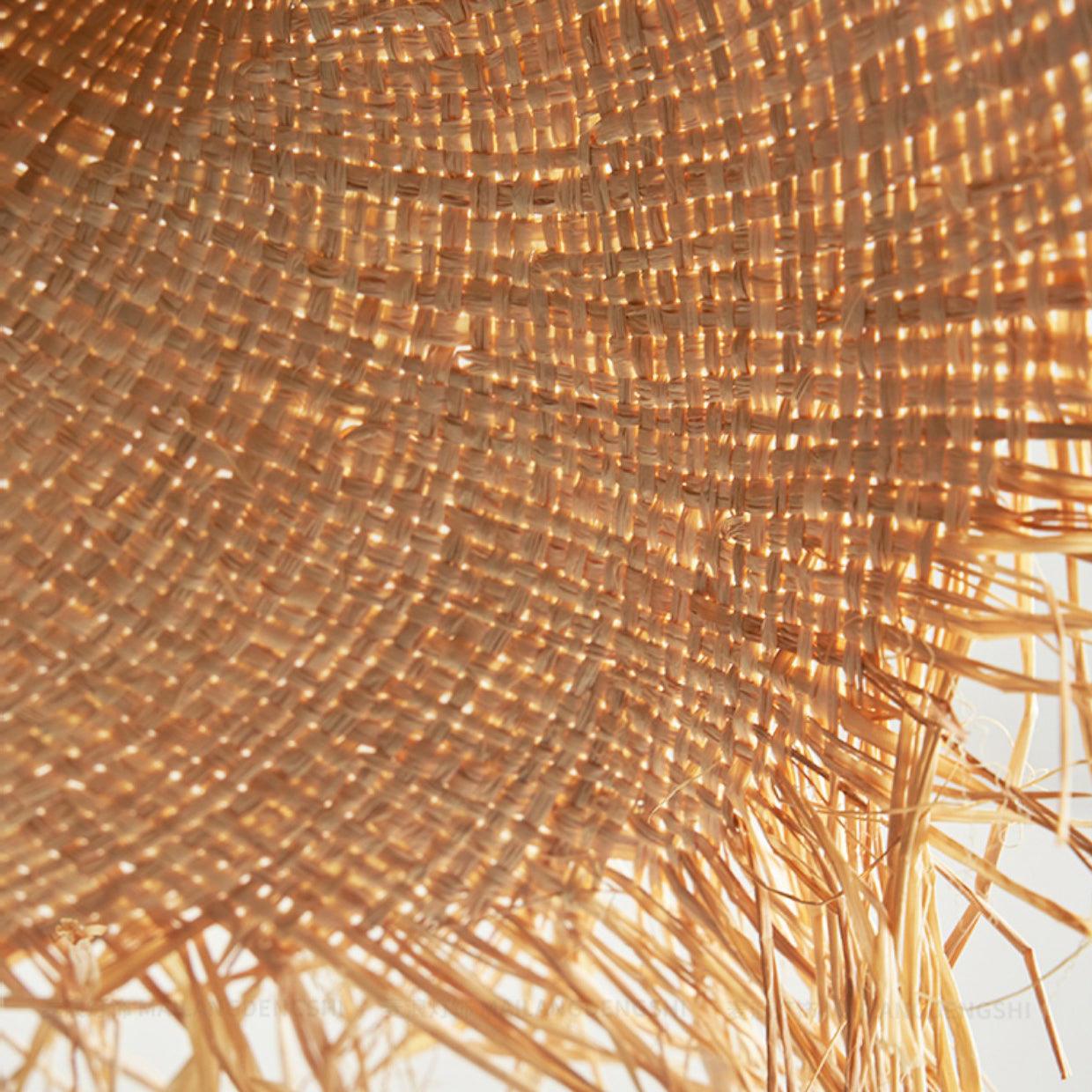 Lit underside detail of woven hat brim, with small points of light between fibers and loose fringe at the edge