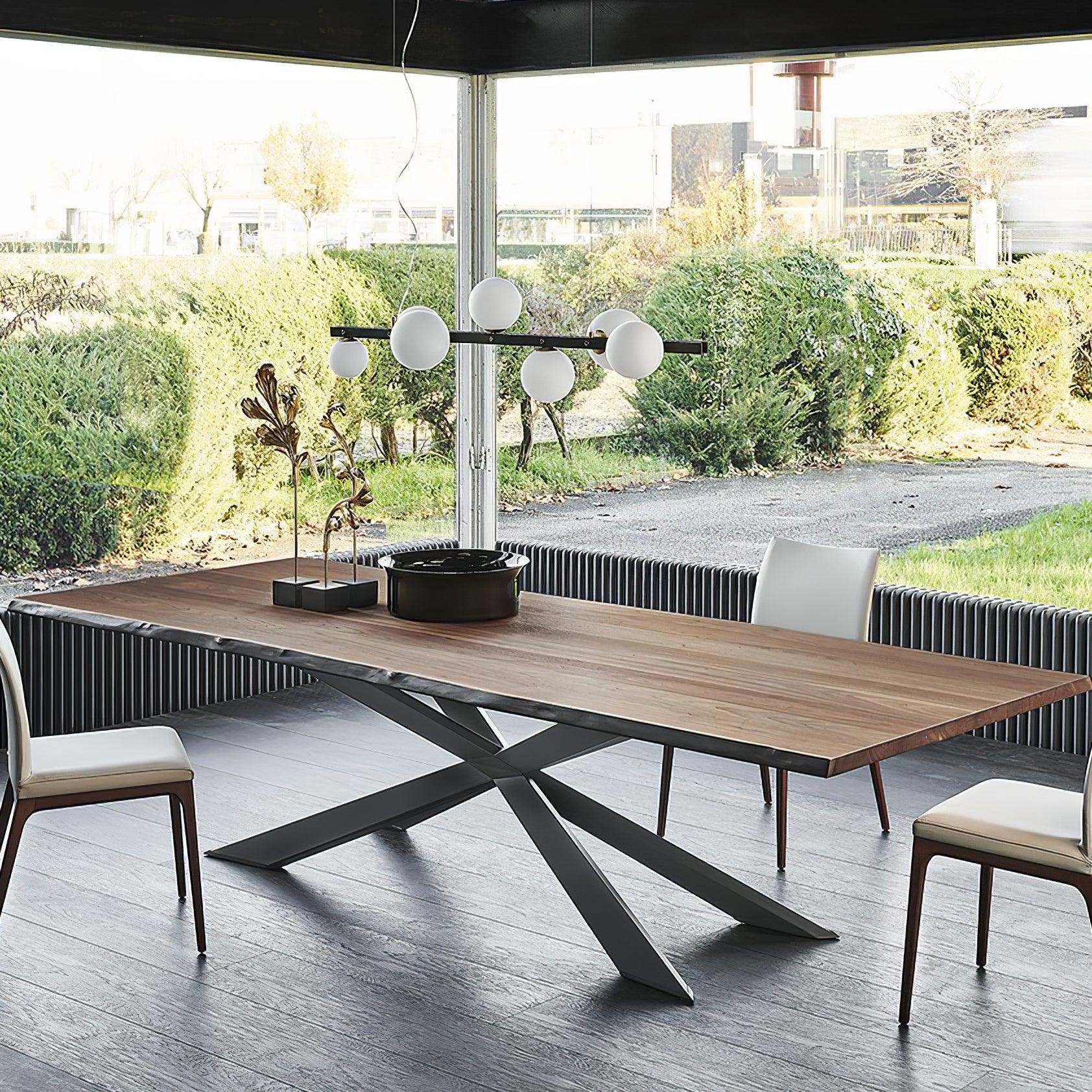 Globe pendant over wood table, white chairs, metal leaf sculpture and dark vessel by garden-facing corner windows.