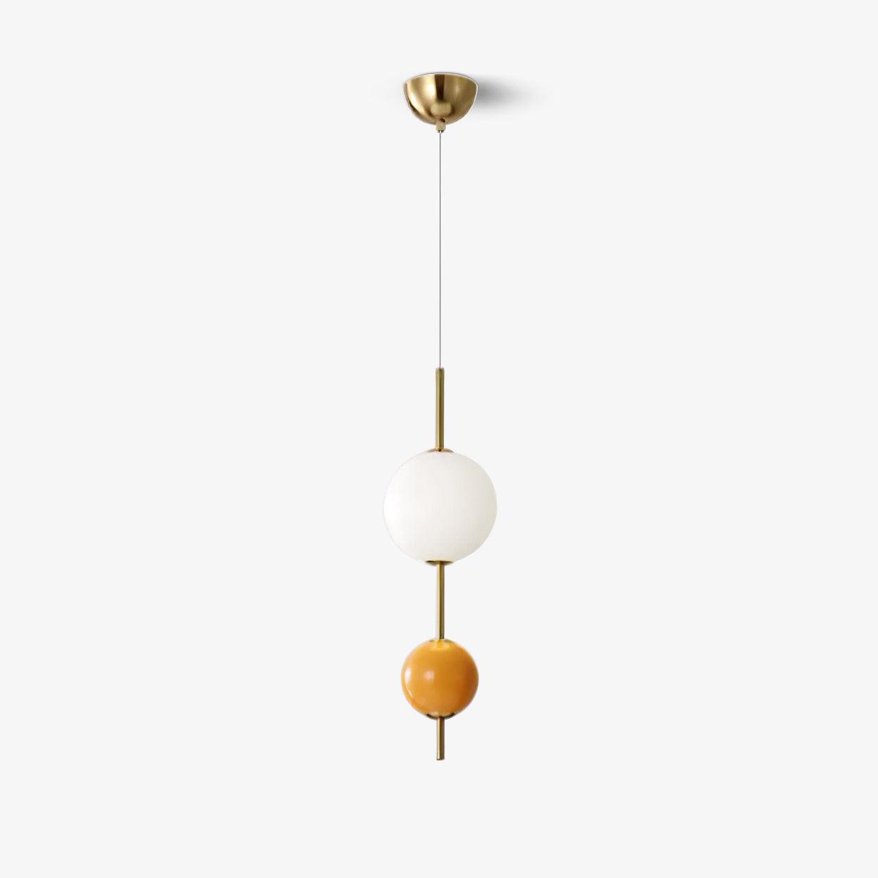 Orange two-ball pendant photographed against a pale background