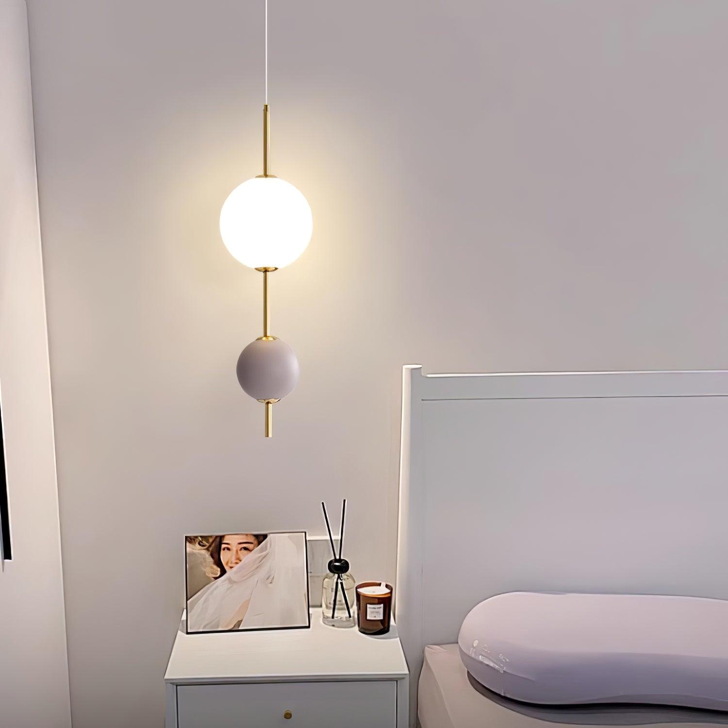 Violet two-ball pendant beside a bed and mirror
