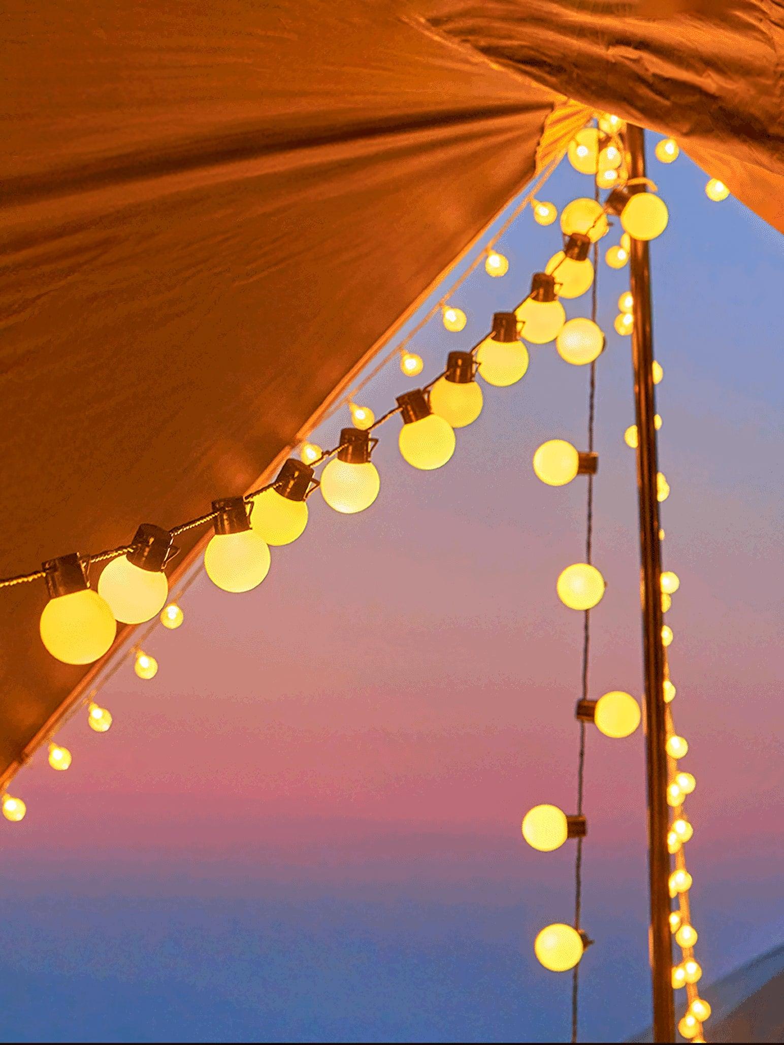 Globe strings along a parasol edge at sunset