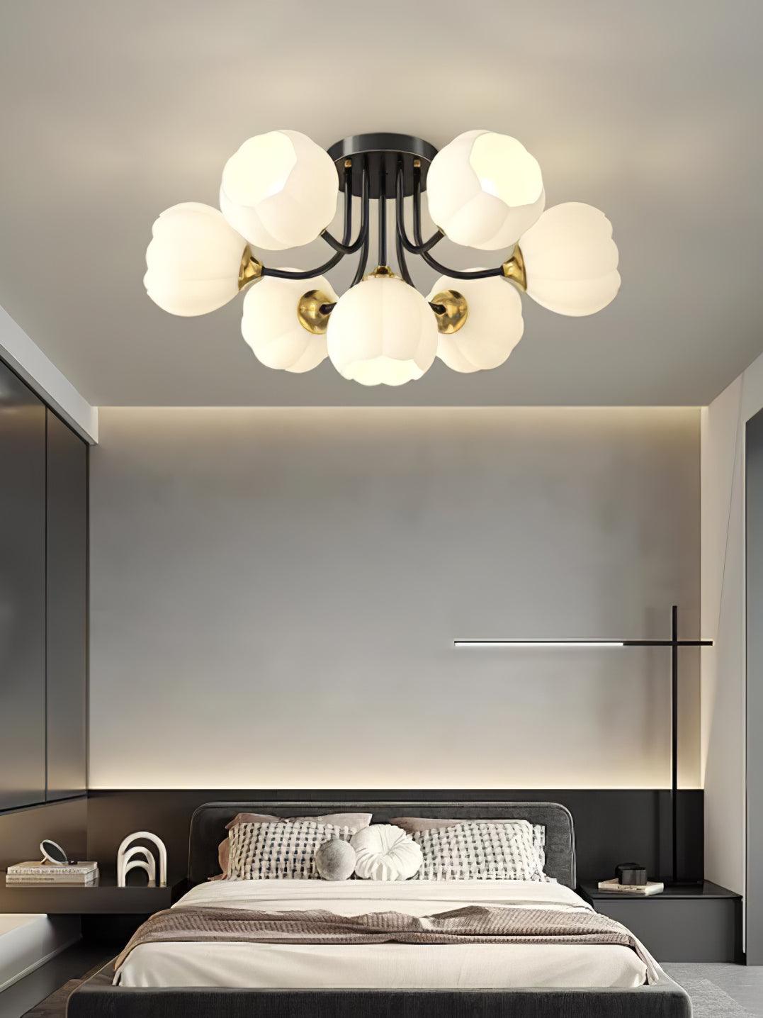Black Pumpkin ceiling light with gold-colour fittings and white shades above a grey bed