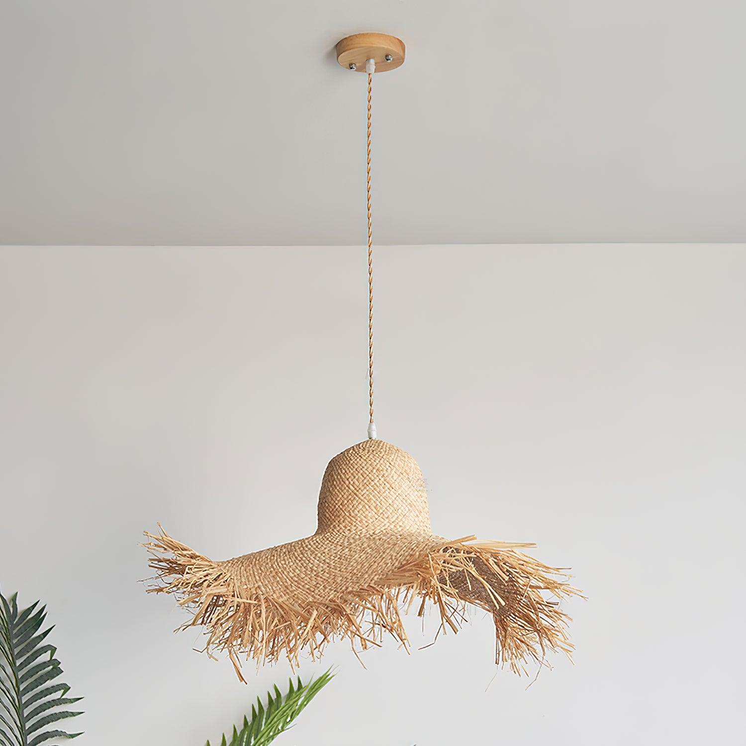 Unlit rattan hat pendant with long tan twisted cord, round natural-toned canopy and palm fronds at left