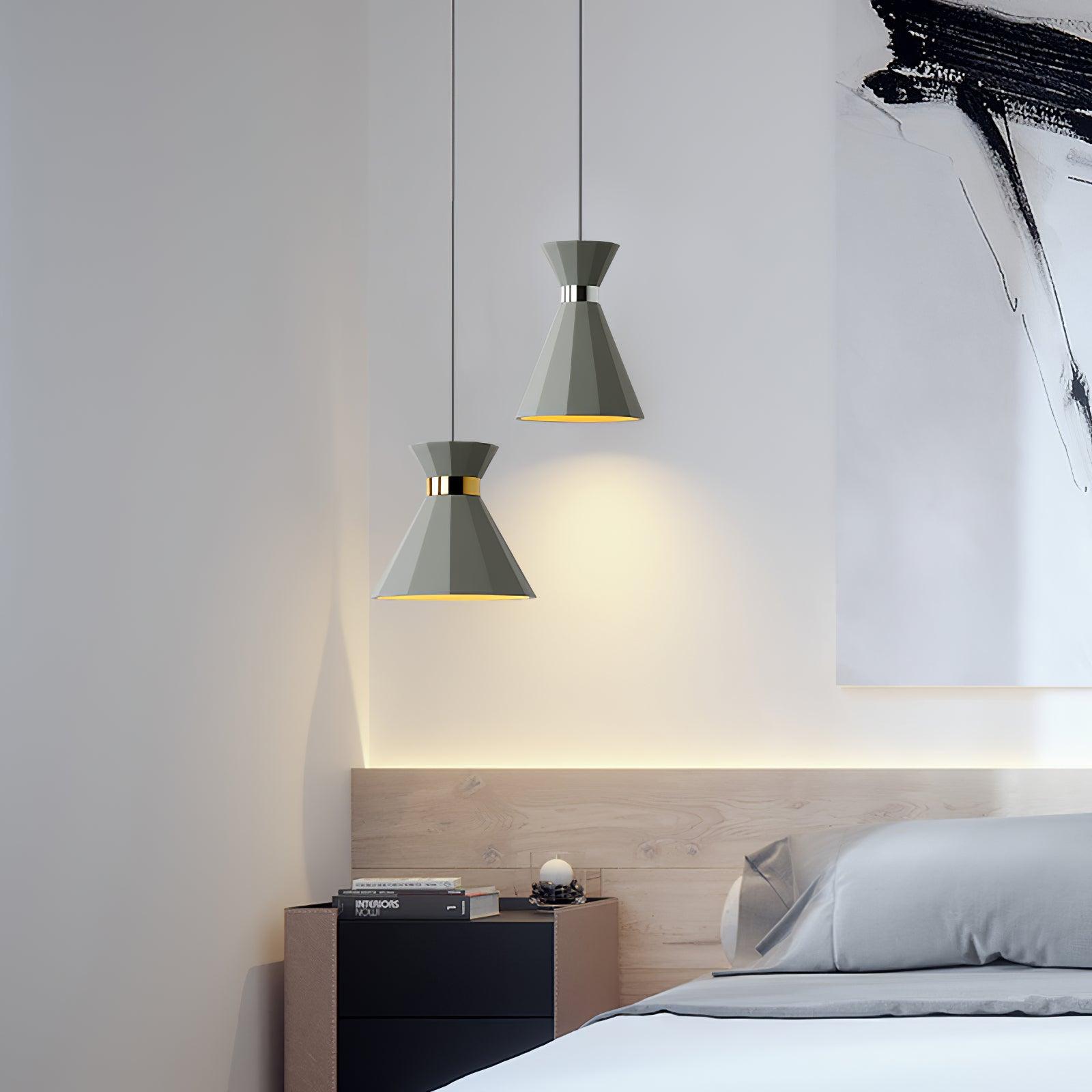 Two grey pendants at staggered heights beside a bed