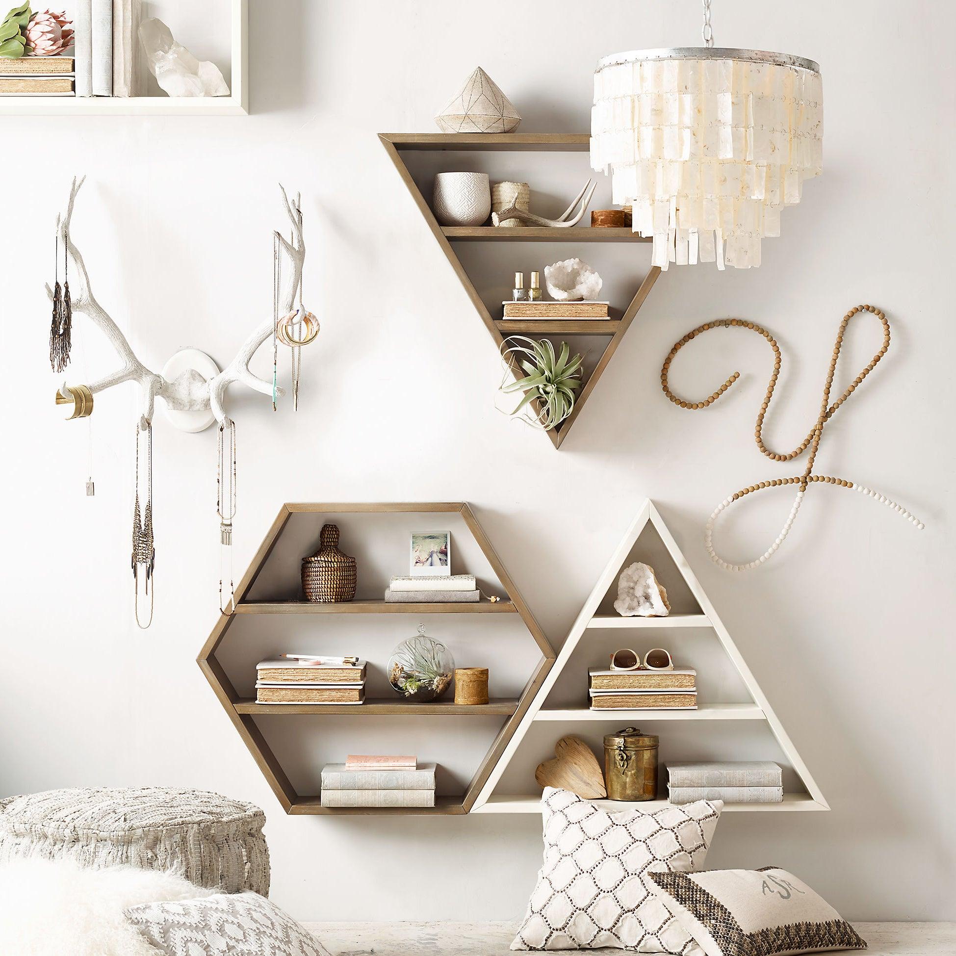 Shell pendant near geometric display shelves, decorative white antlers, jewellery and patterned cushions