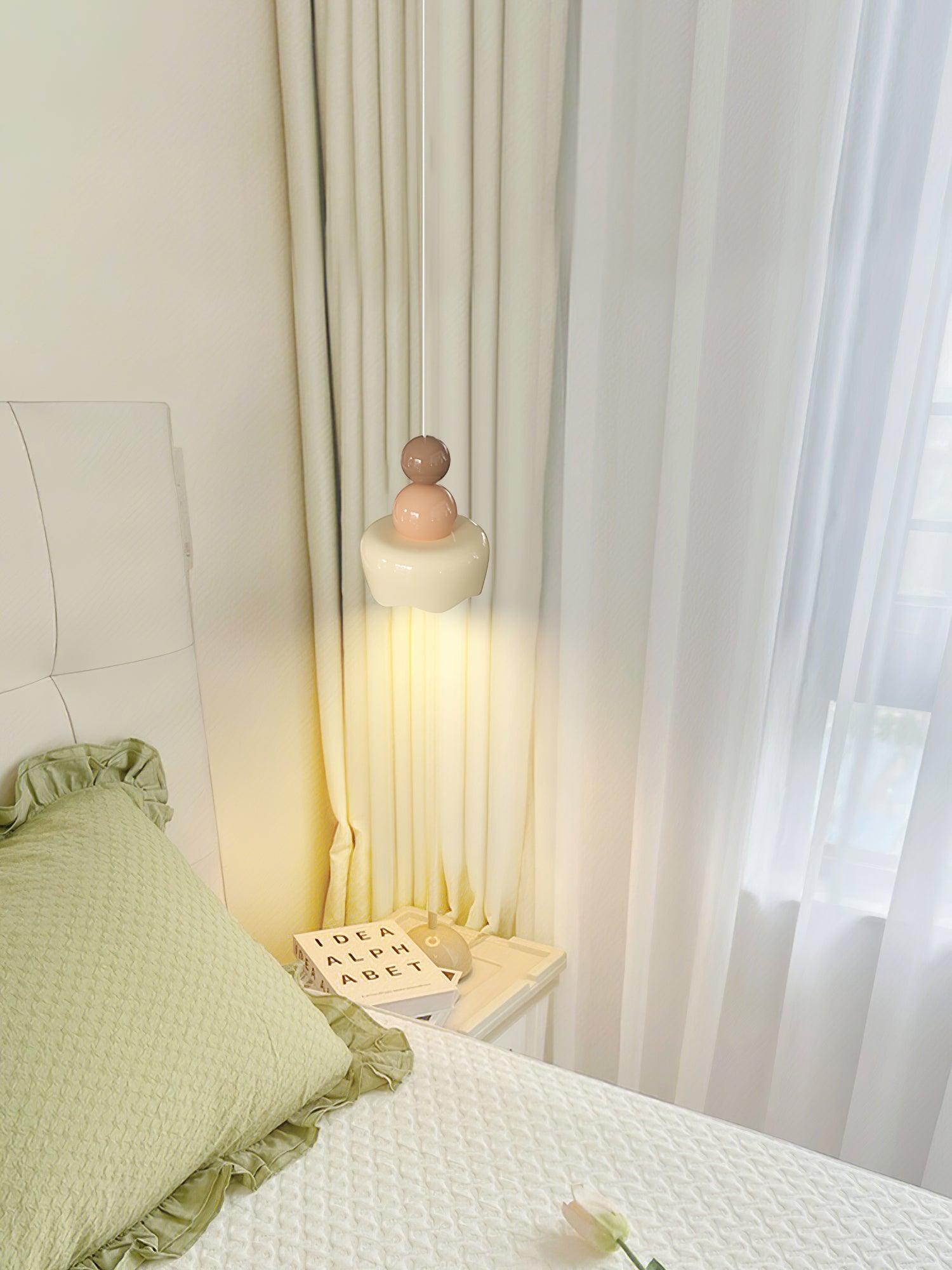 Doll-form pendant beside a bed and curtains