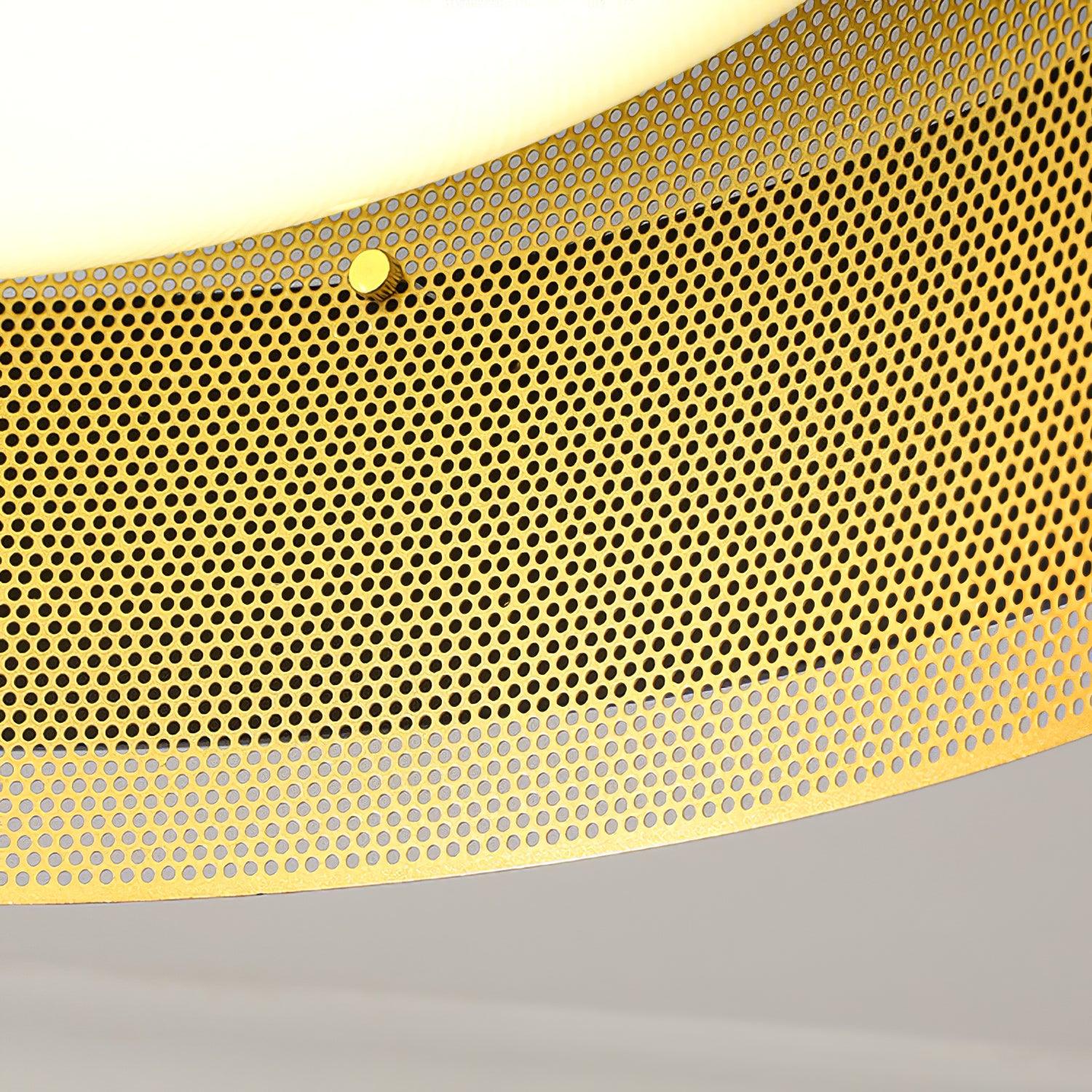 Close perforated gold-tone metal surface, small round fastener and white diffuser