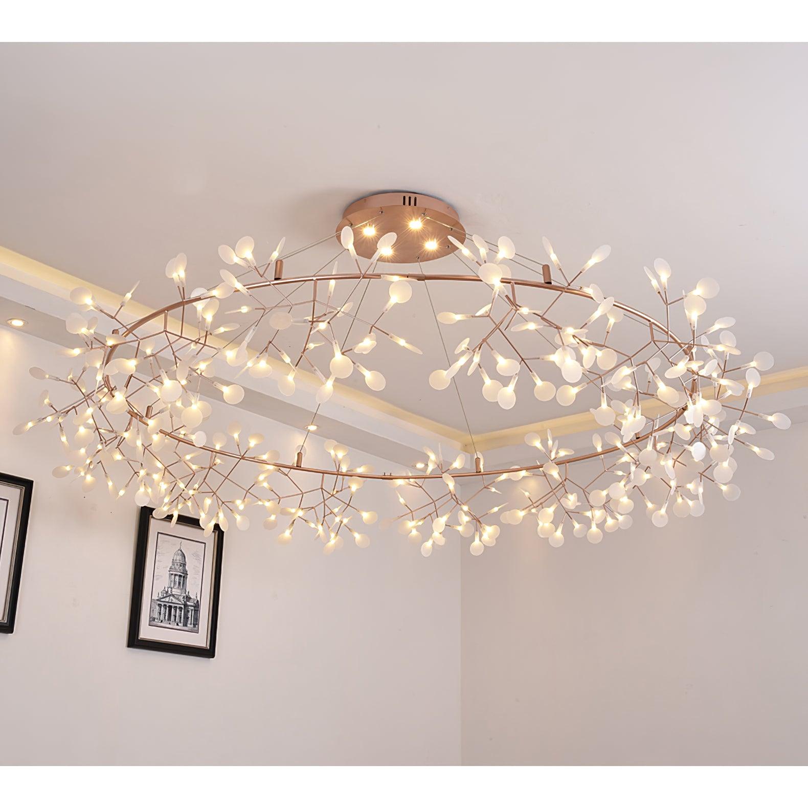 Wide leaf ring chandelier lit near a pale ceiling above framed architectural drawings