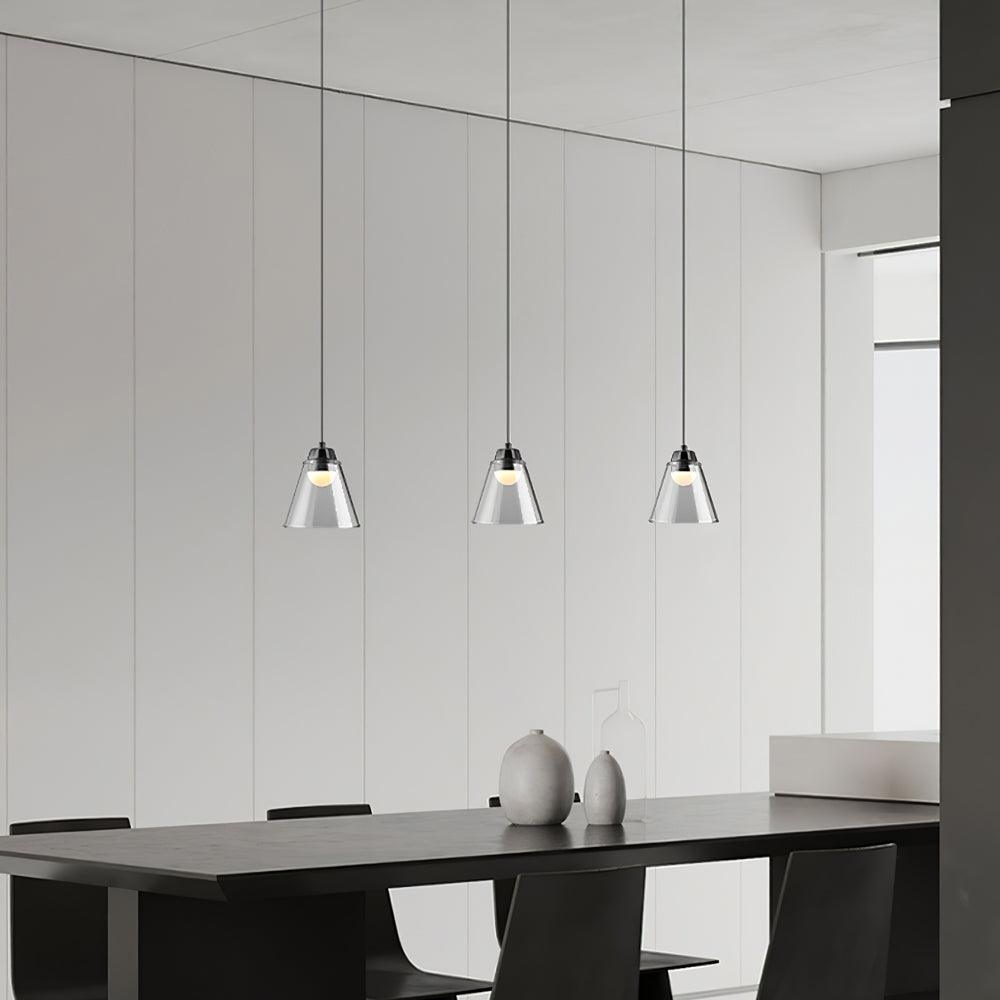 Three separate clear pendants above a dining table