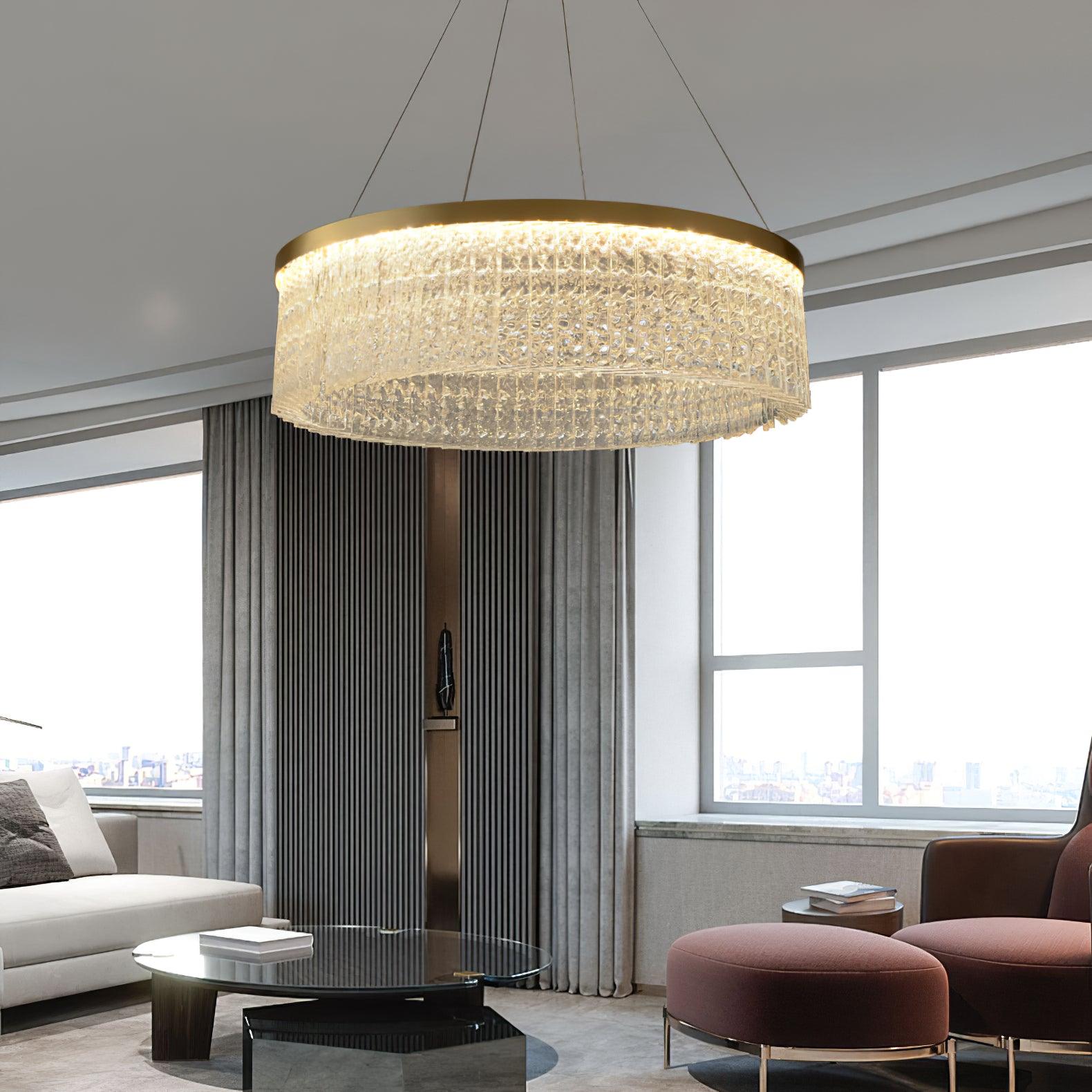 Crystal ring chandelier in a pale living room with grey curtains, white sofa, mauve chair and nested dark round tables
