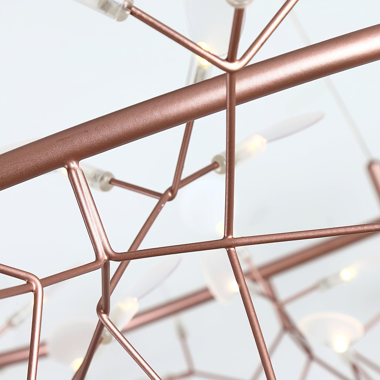 Rose-copper ring and branching rod junctions in close-up, with white oval leaves behind