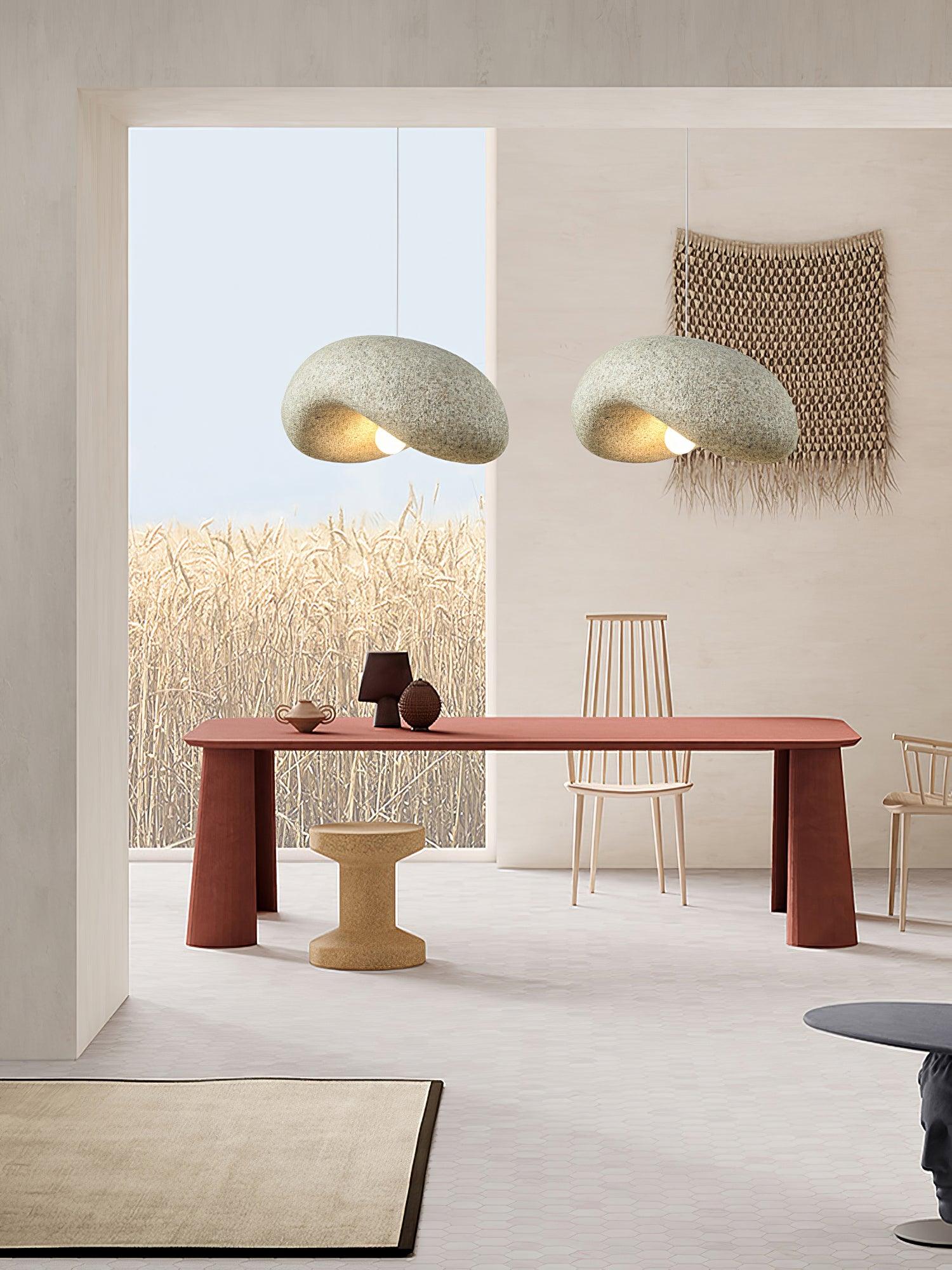 Two organic curled pendant shades above a pink dining table