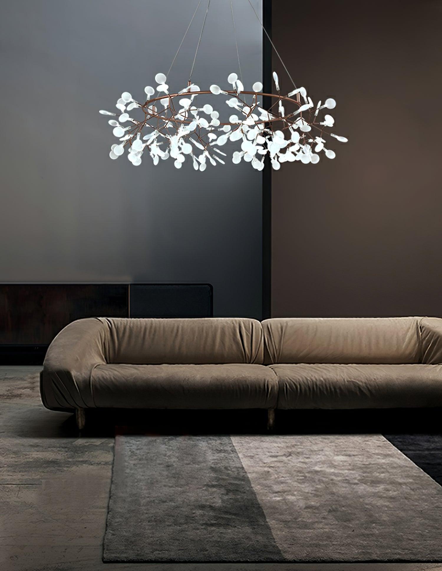 Bright white leaf ring chandelier above a curved pale sofa on a grey rug against a two-tone wall