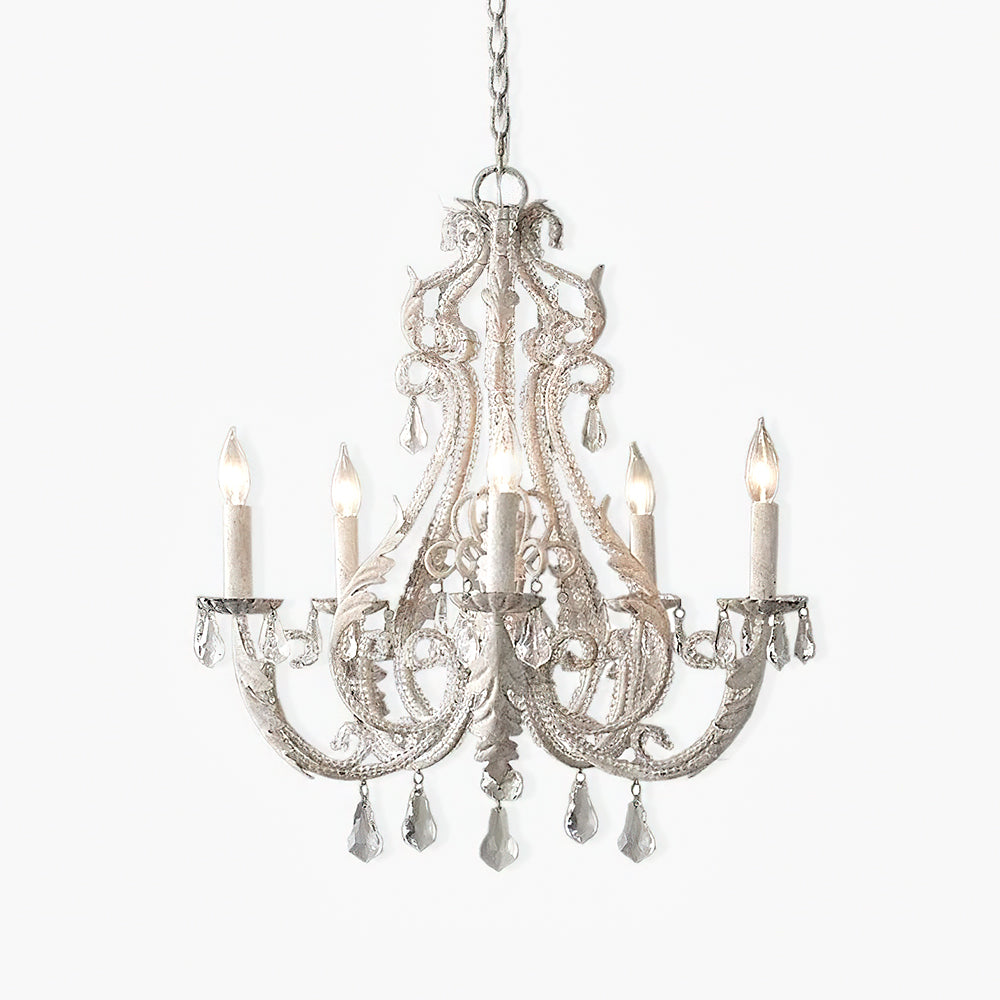 Isolated antique-toned five-light chandelier with crystal beads, metal leaves, teardrops and an elongated centre drop.