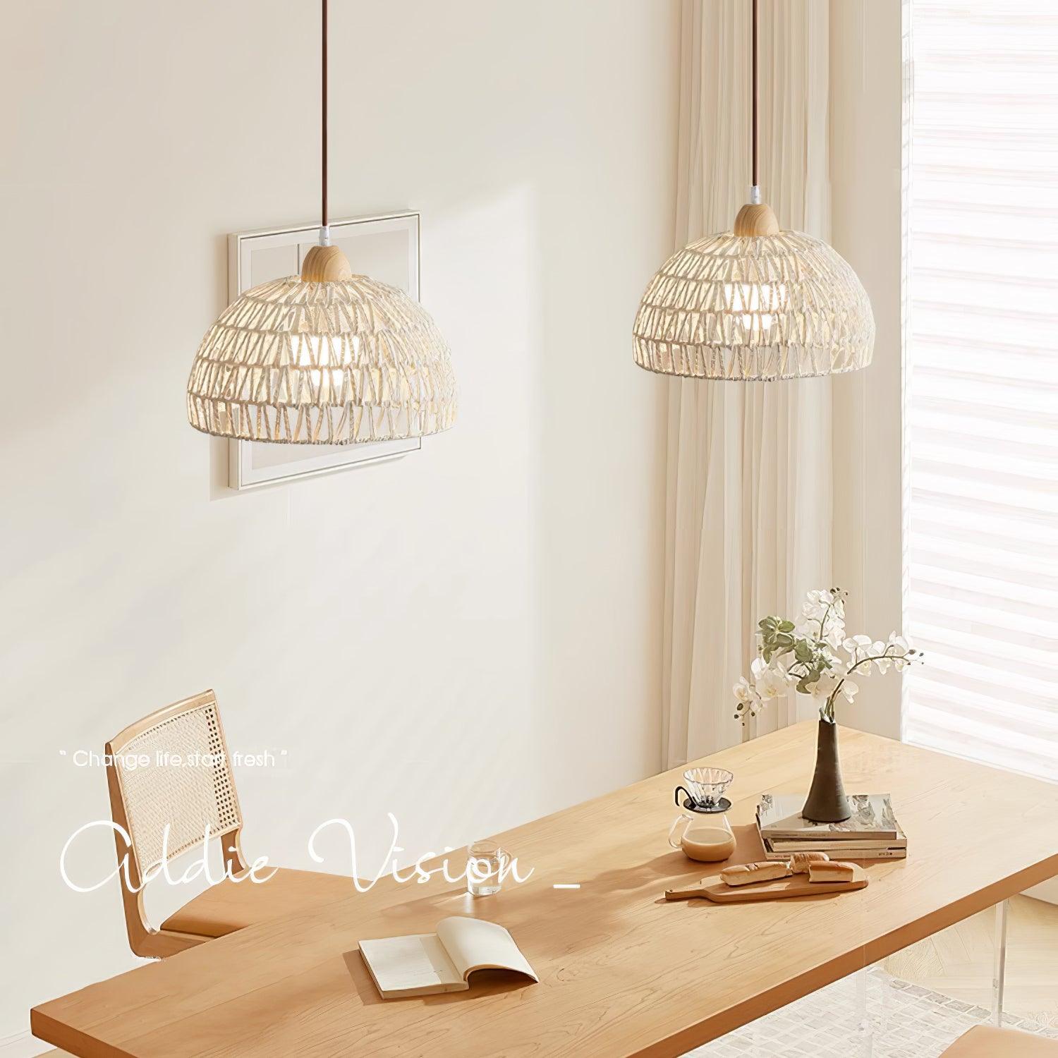 Two woven dome shades above a wood dining table with books, coffee and orchids beside curtains and blinds