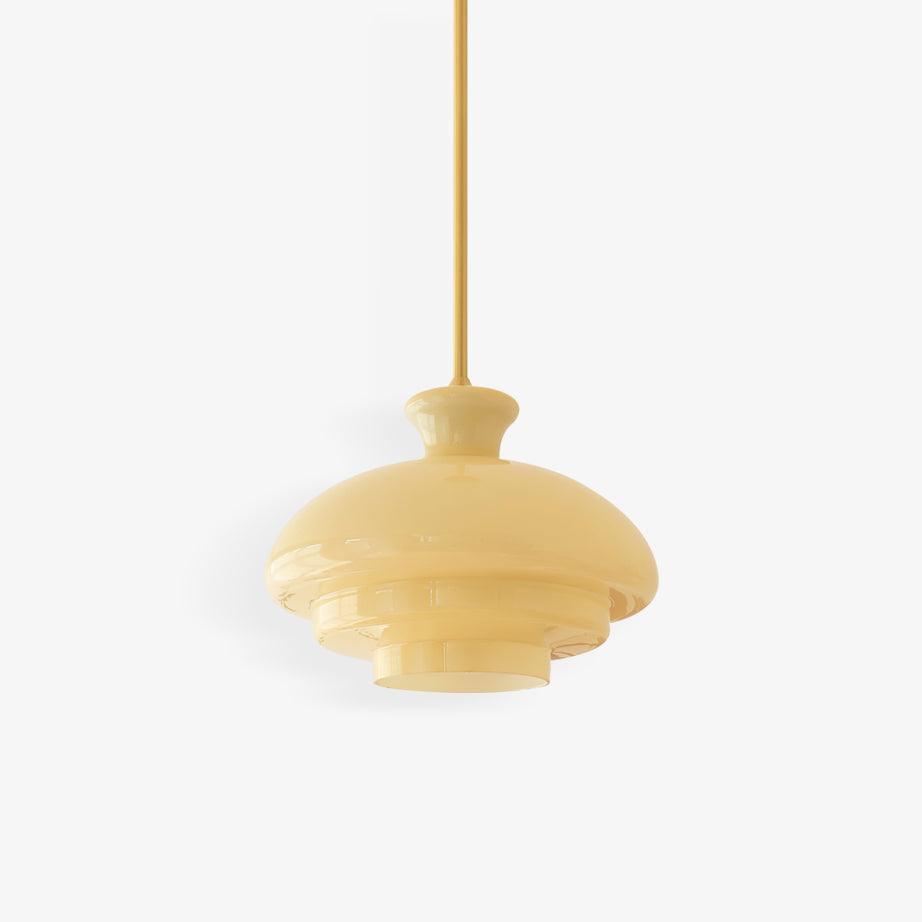 Alternate isolated yellow stepped glass dome and slender gold-tone rod on white
