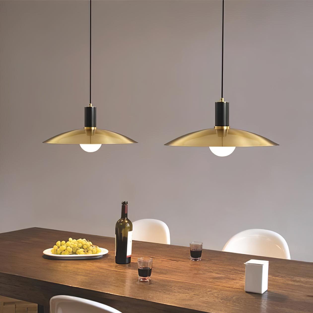 Two brass-shade pendants with black fittings above a table