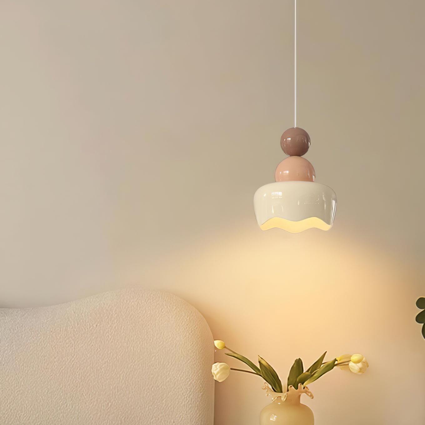 Pink-and-cream pendant above bedside flowers