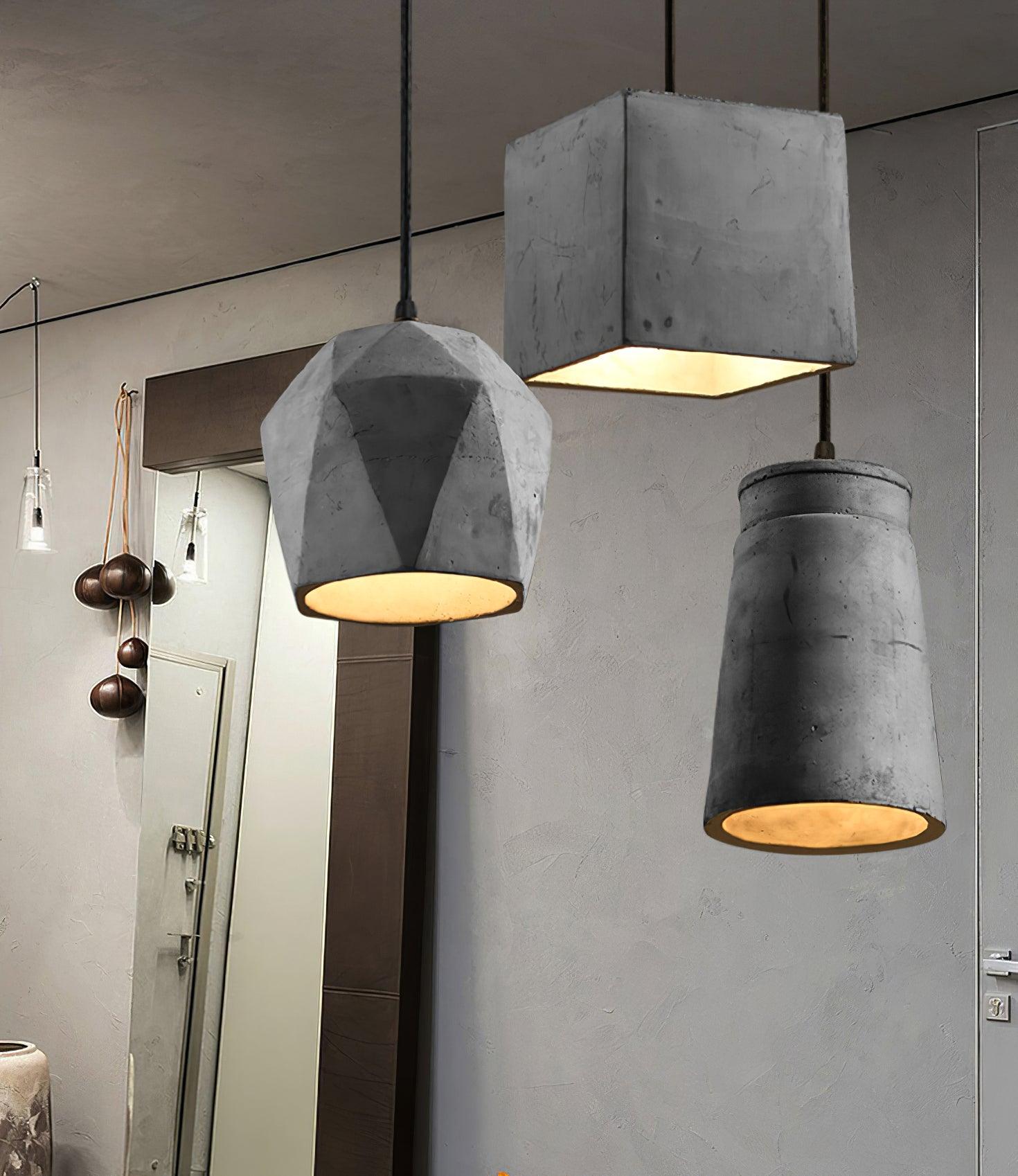 Three geometric cement pendants near a wall