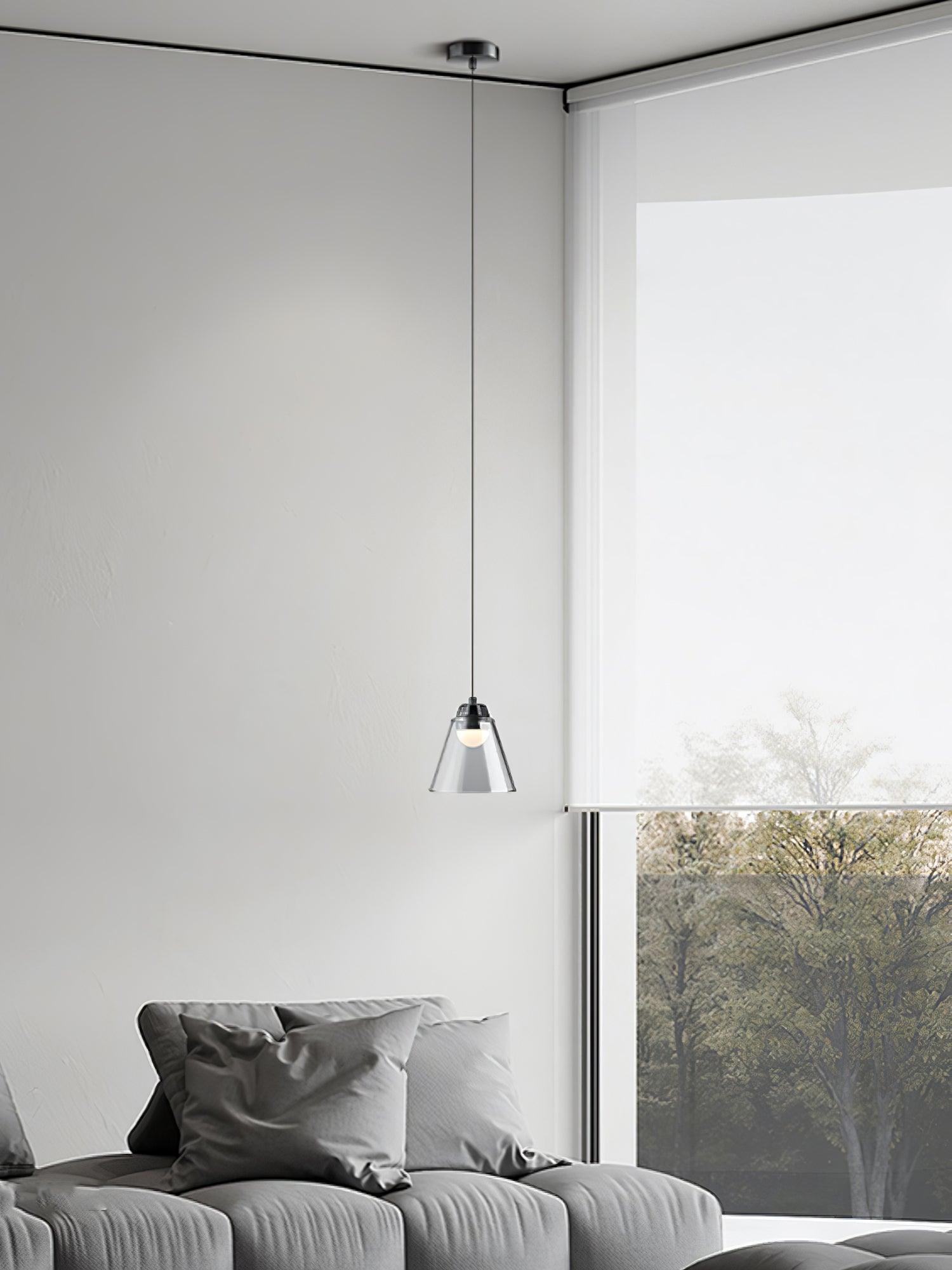 Single clear pendant near a window and sofa