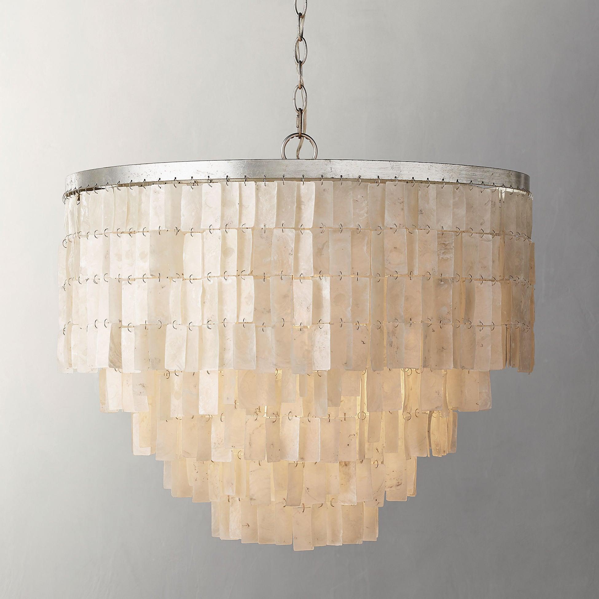 Close view of a deep tiered shell shade with broad upper rows, narrowing lower steps, silver ring and chain