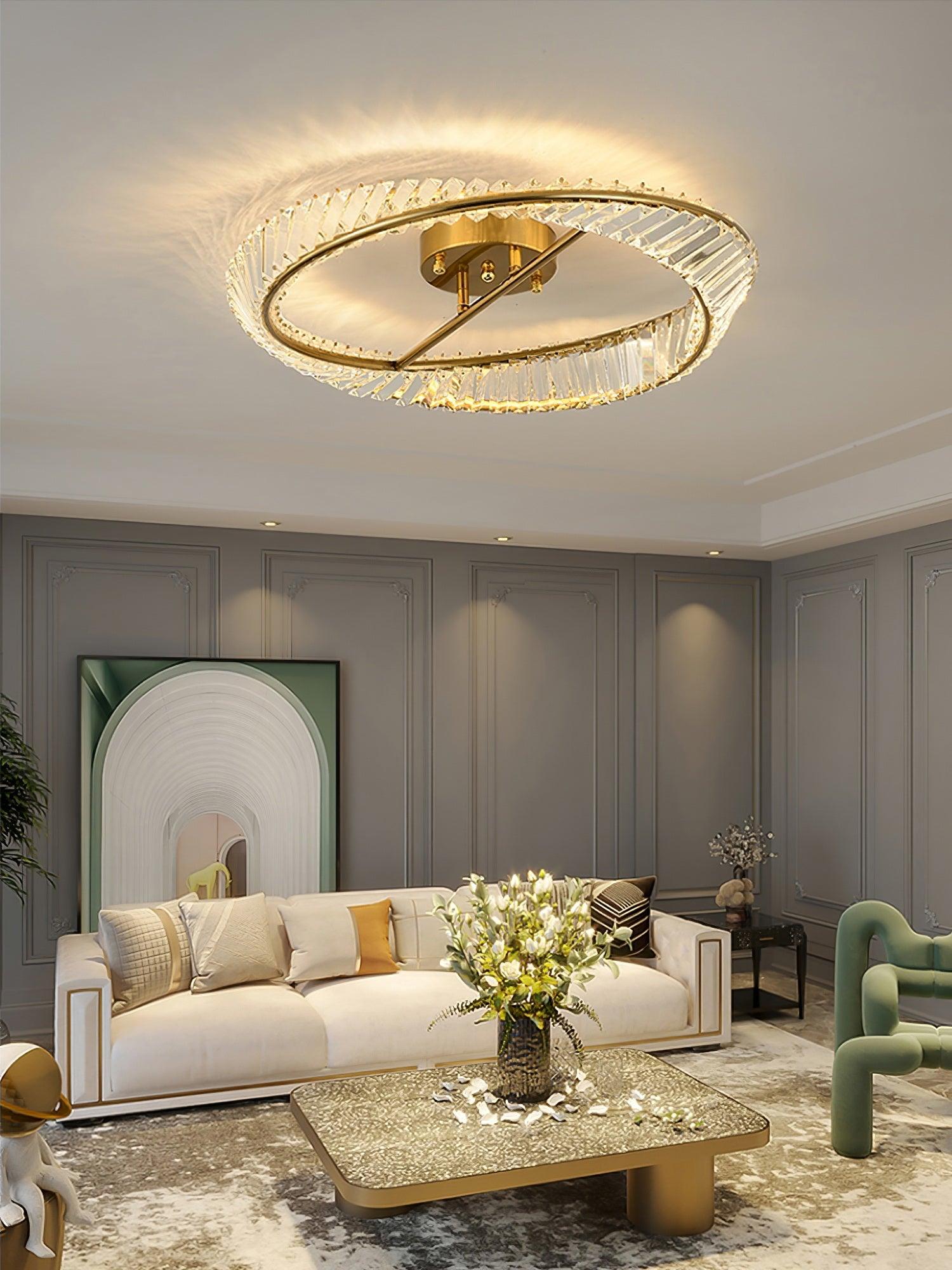Glass ring ceiling light above a white sofa, floral arrangement and square gold-tone coffee table