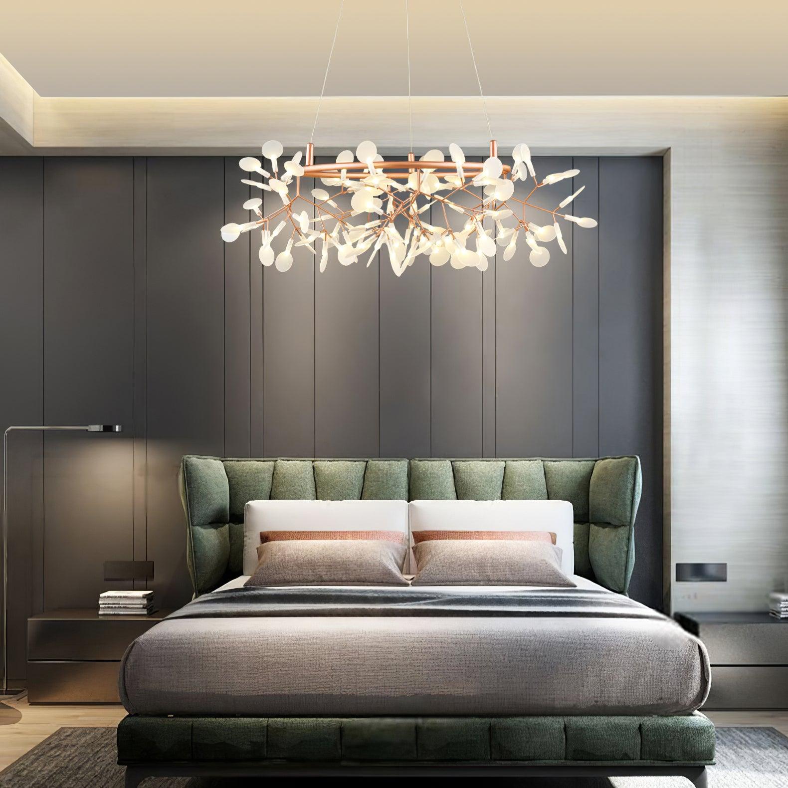 Small rose-copper leaf ring chandelier above a grey bed with a green headboard and pink-striped pillows