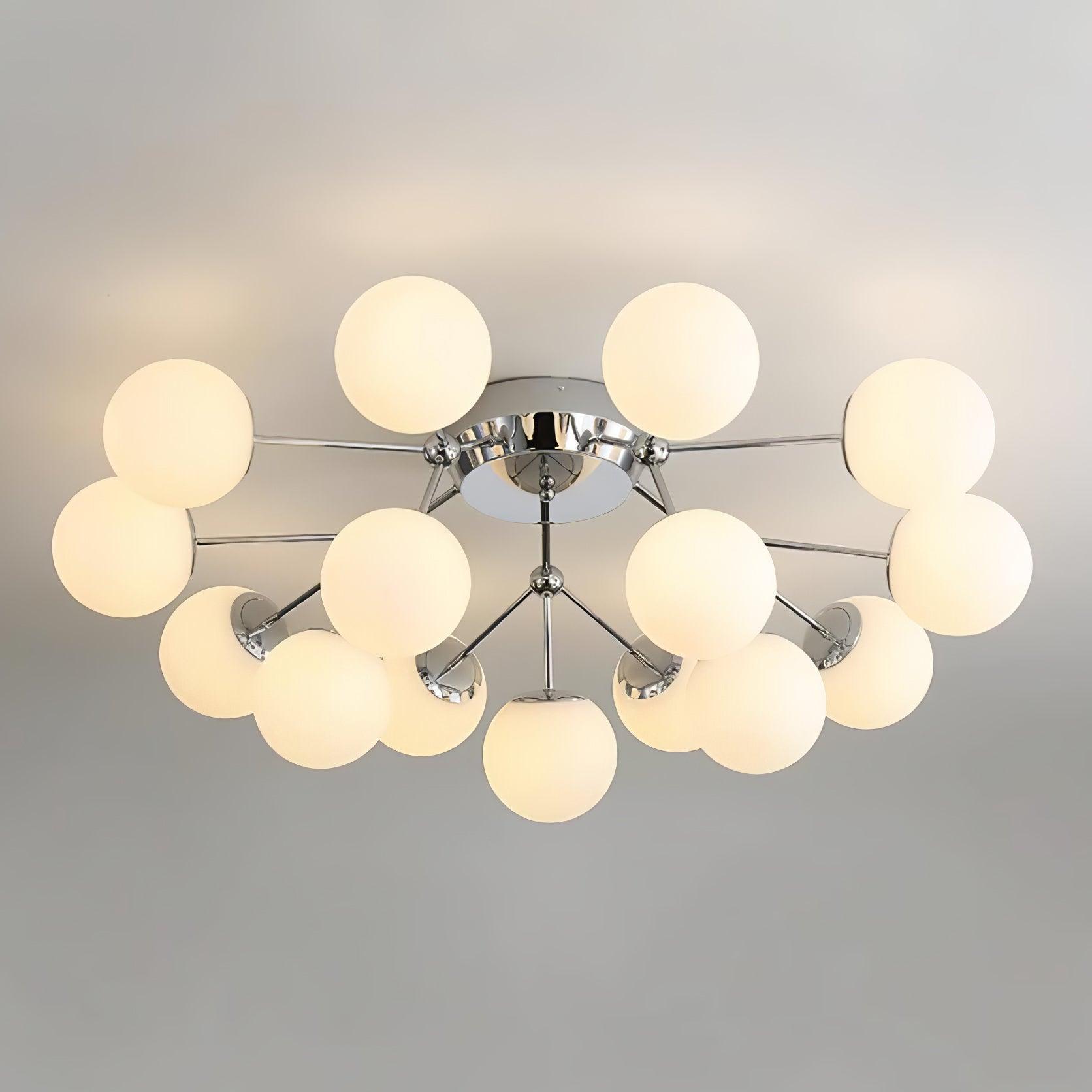 Chrome globe-cluster ceiling light glowing warm against a gray ceiling, showing layered rods and reflective globe caps