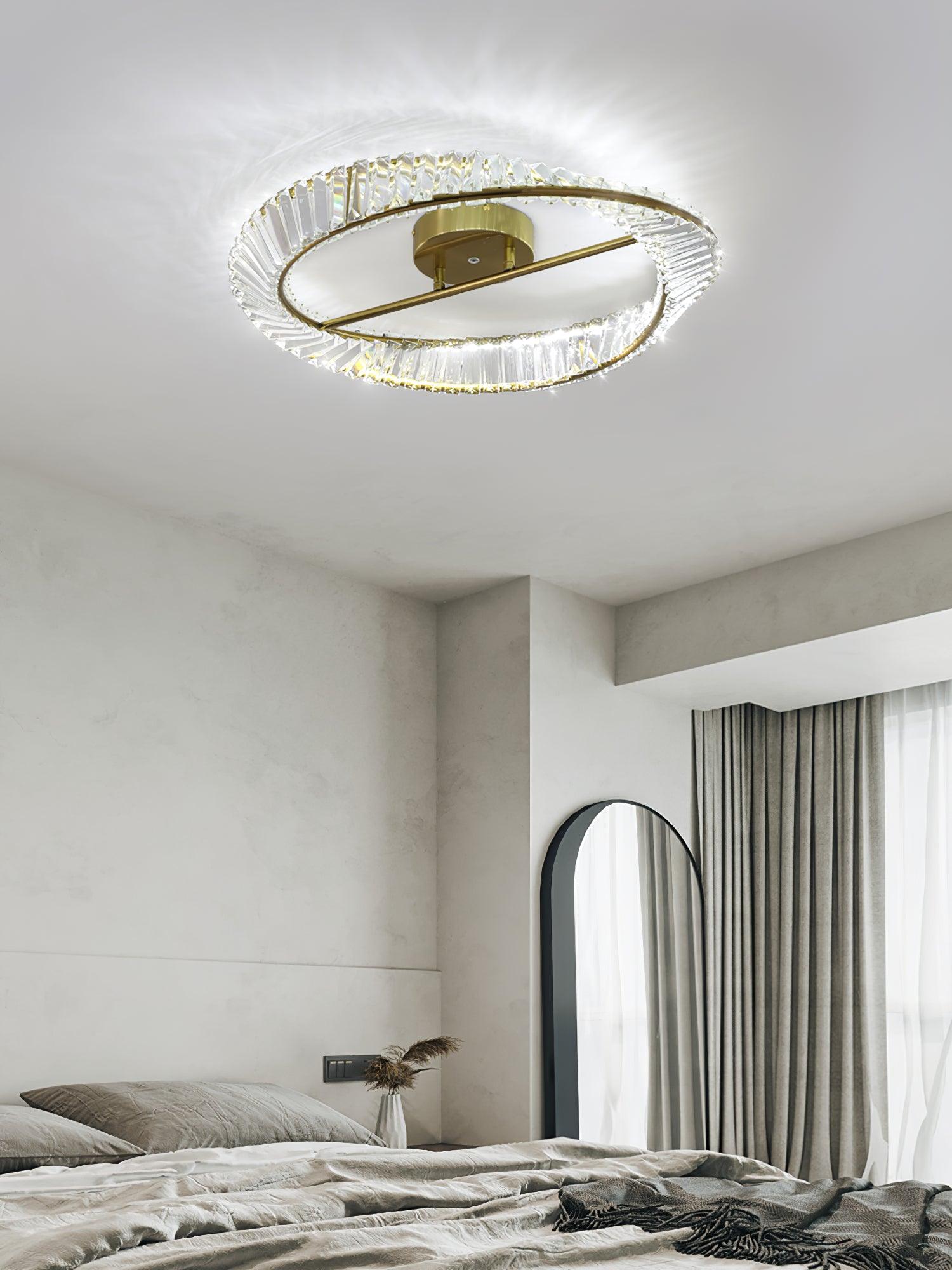 Bright ring ceiling light above a bed with grey bedding beside an arched mirror