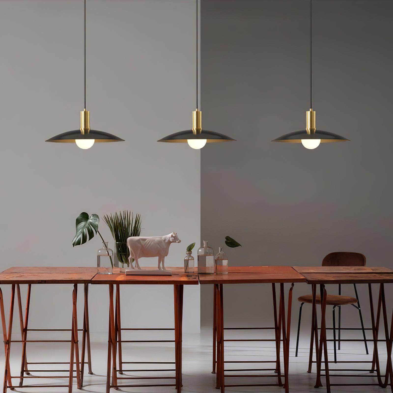 Three separate black flared pendants above a table