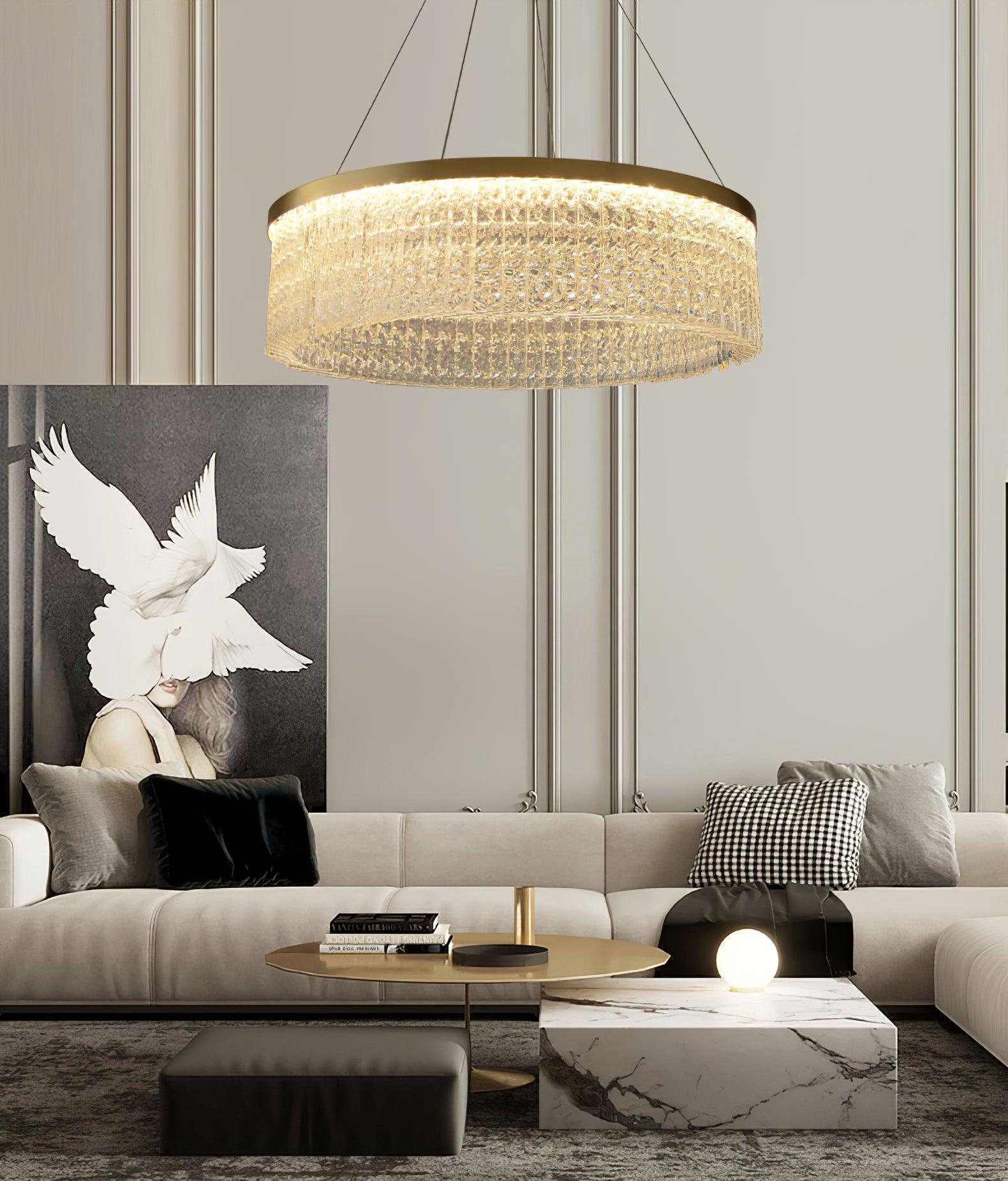 Crystal ring above pale sofa with black and check cushions, gold-tone table, stone block table and white-bird artwork
