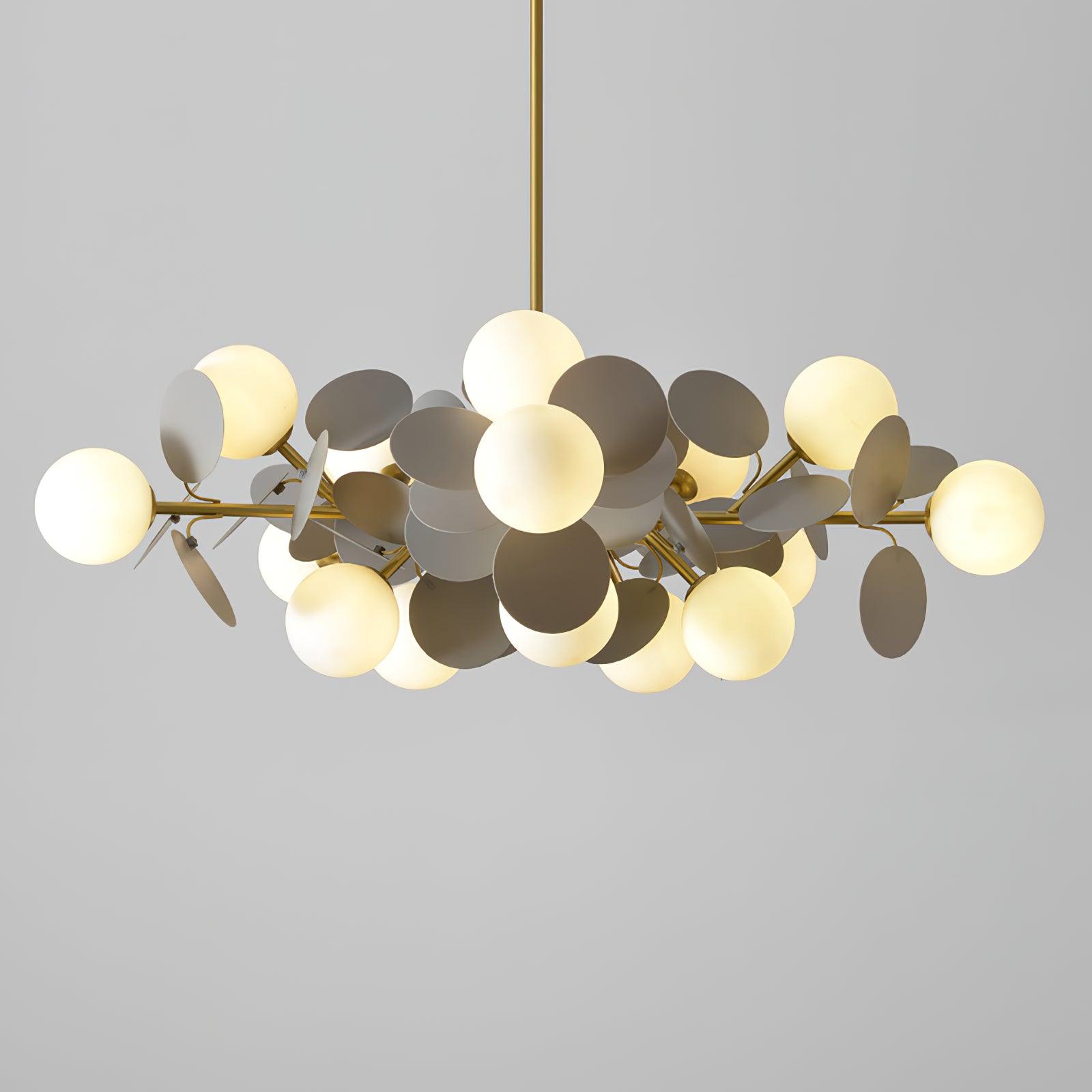 Gold-and-grey Off White Tree chandelier illuminated against grey, with circular leaf discs and white globes