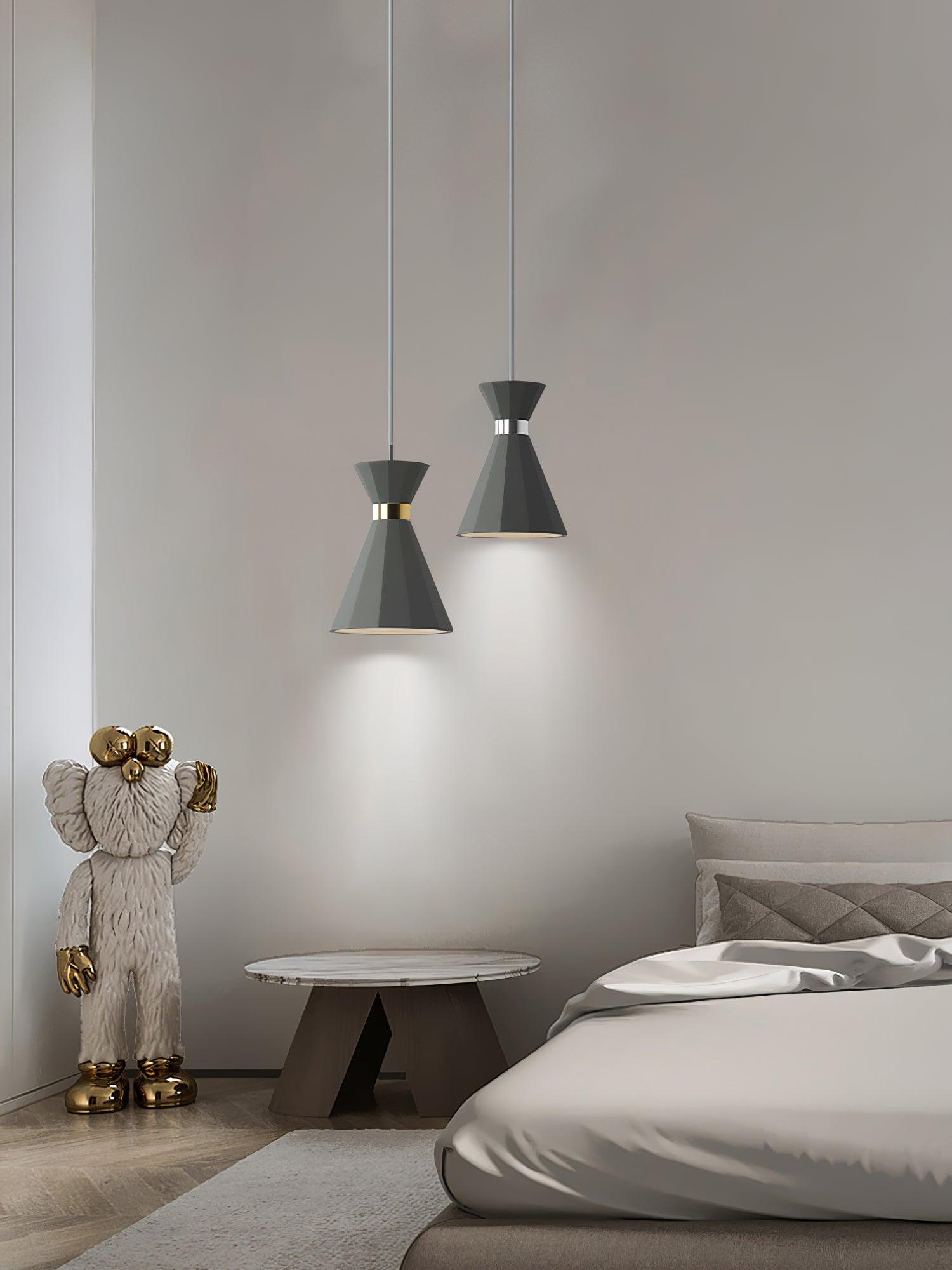 Tall grey pendants beside a bed and small table