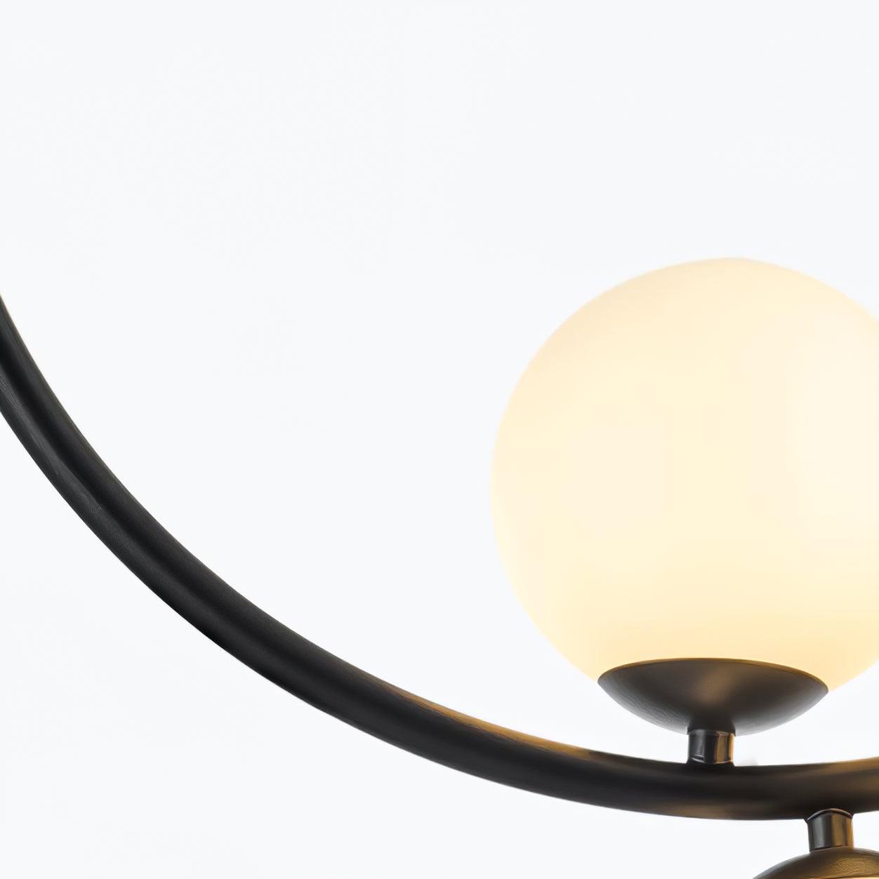 Lit white globe seated on a dark holder beside the ring
