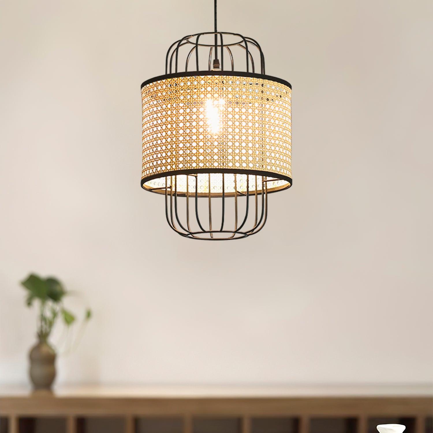 Lit woven rattan and black cage pendant above a wooden console in a pale interior