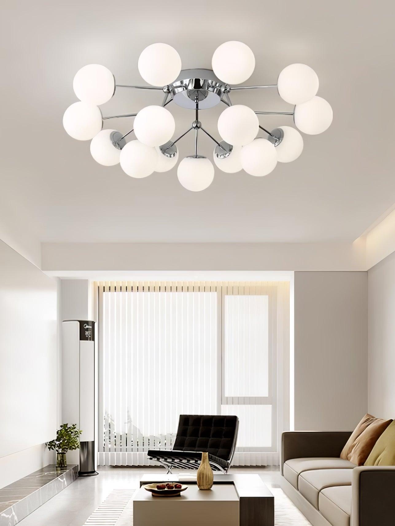 Chrome white-globe ceiling light above a dark tufted lounge chair, pale sofa and coffee table with vase beside window blinds