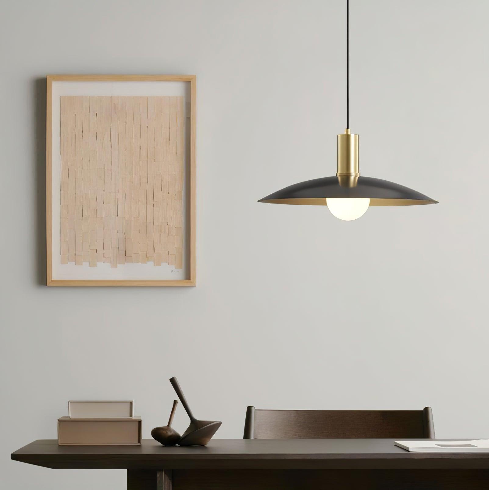 Black-shade pendant with brass-colour cap above a table