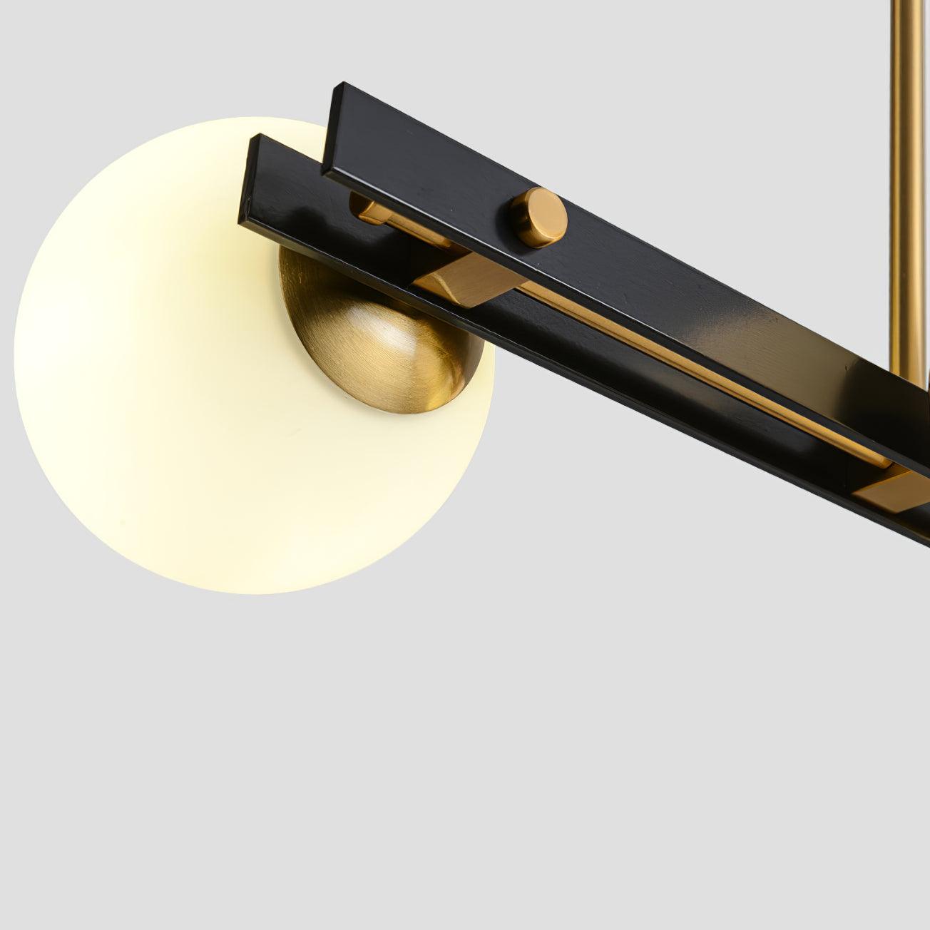 Close underside of black channel bar, round gold-tone fastener and brass-tone globe fitting, with glowing shade and rod.
