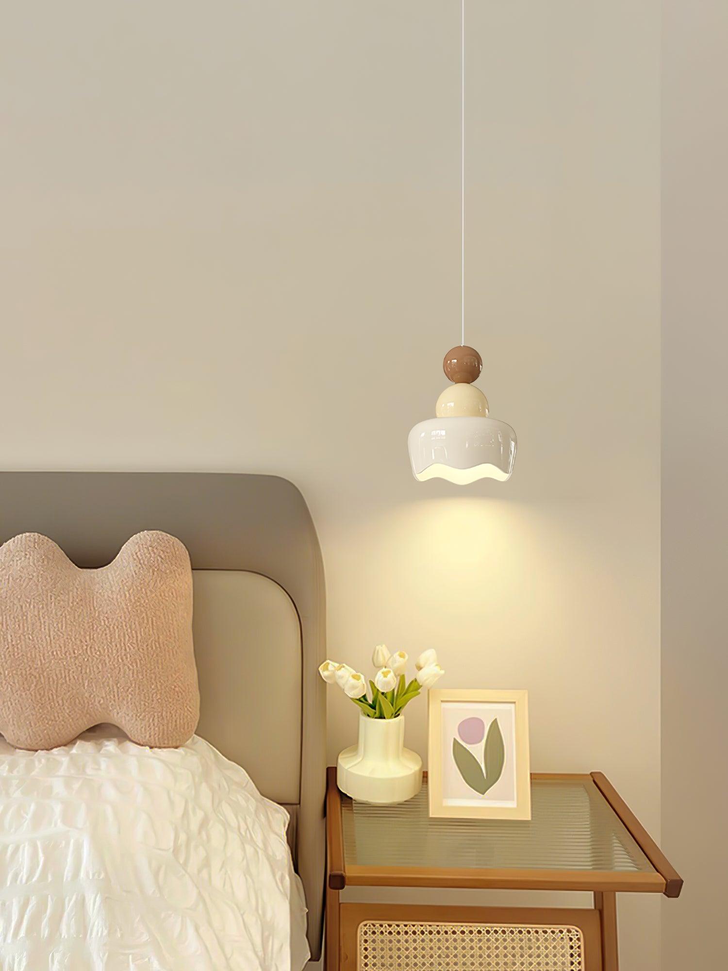 White-and-cream doll pendant beside a bed