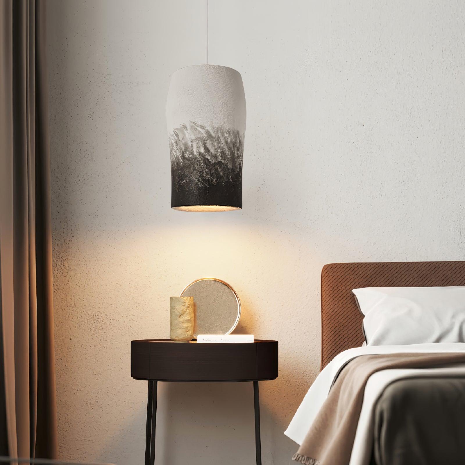 Grey and black textured pendant beside a bed