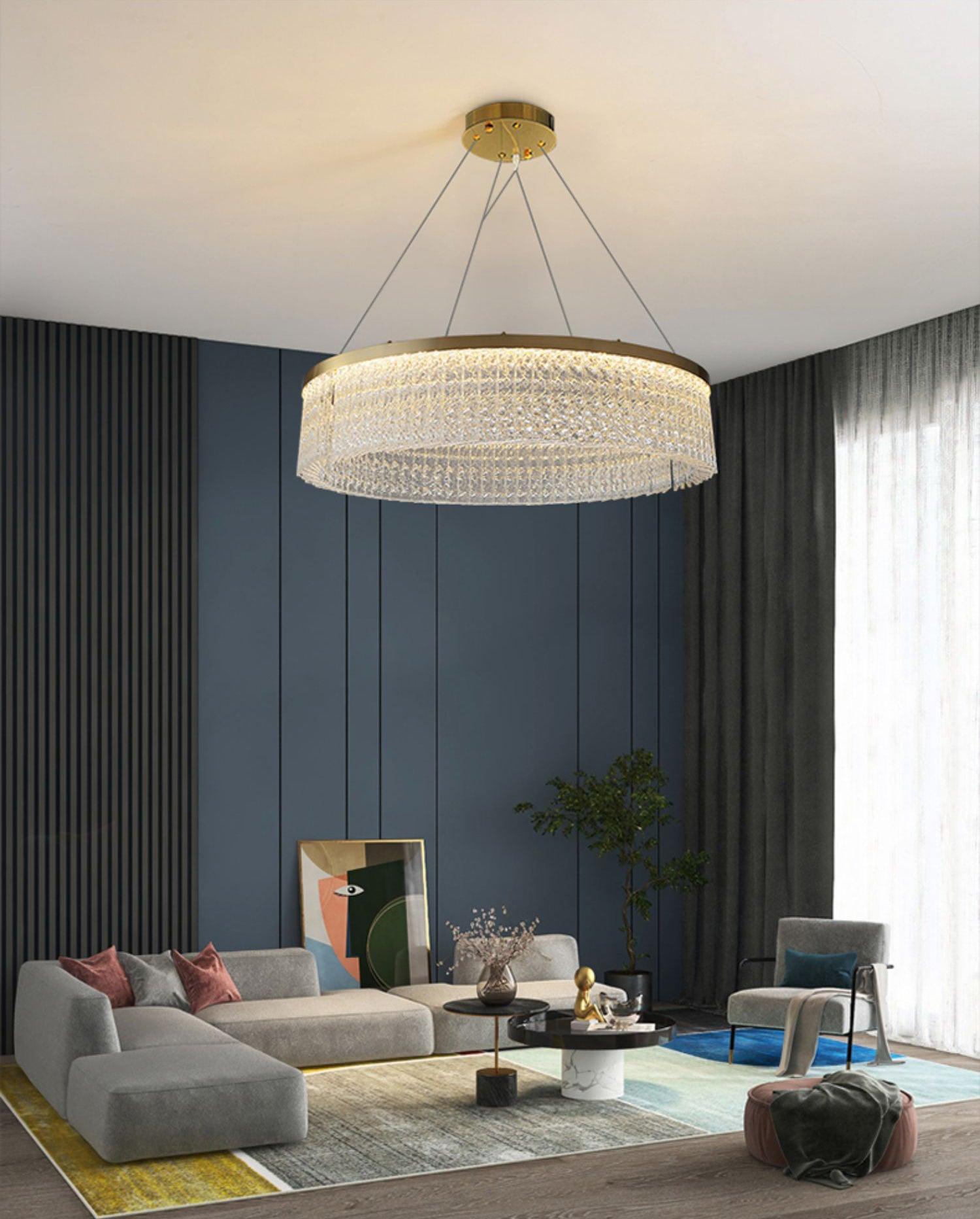 Crystal ring in a blue-panelled living room with grey sofa, chair, round coffee tables, plant and tall curtains