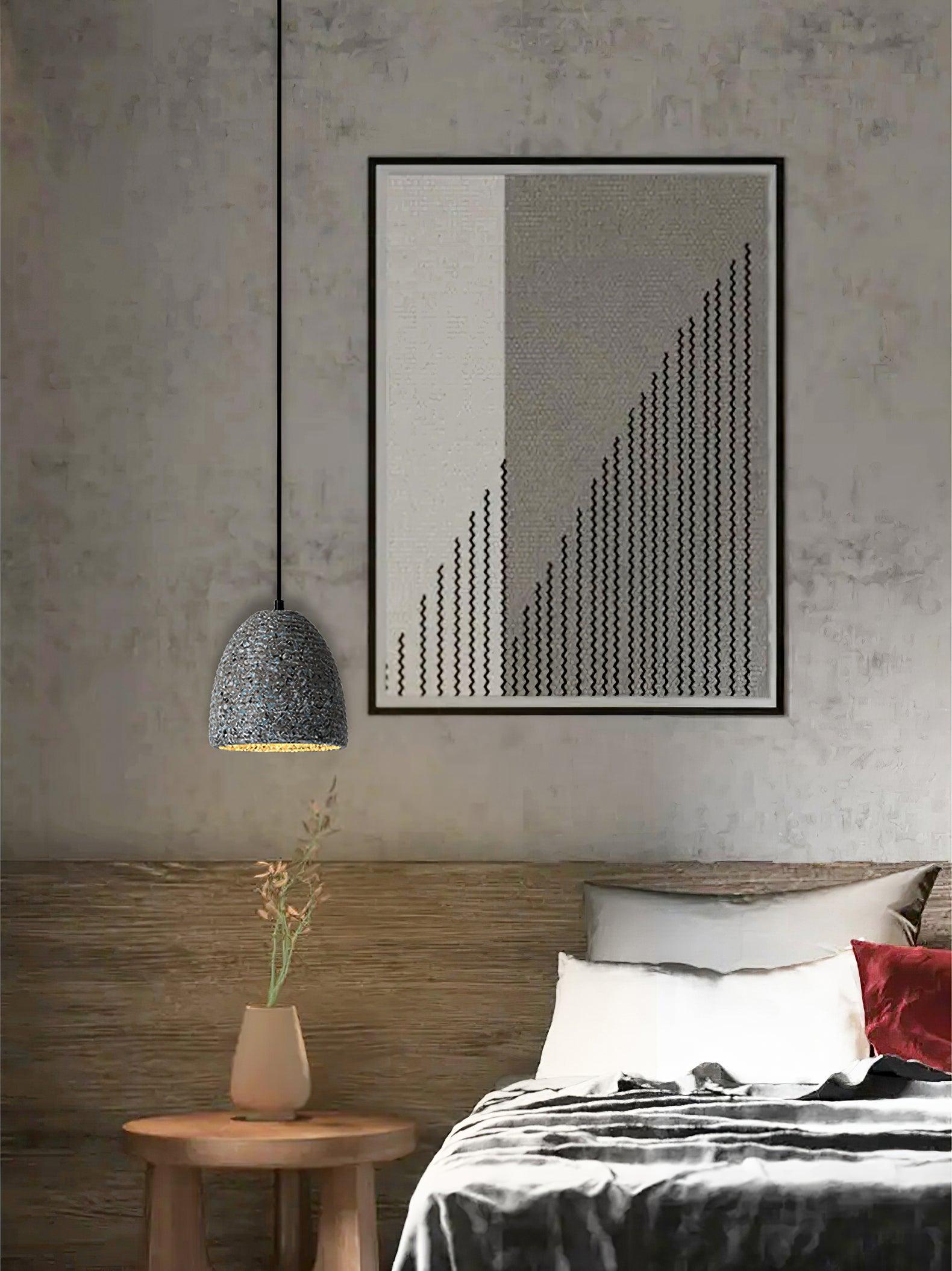 Grey cement pendant against a concrete bedroom wall