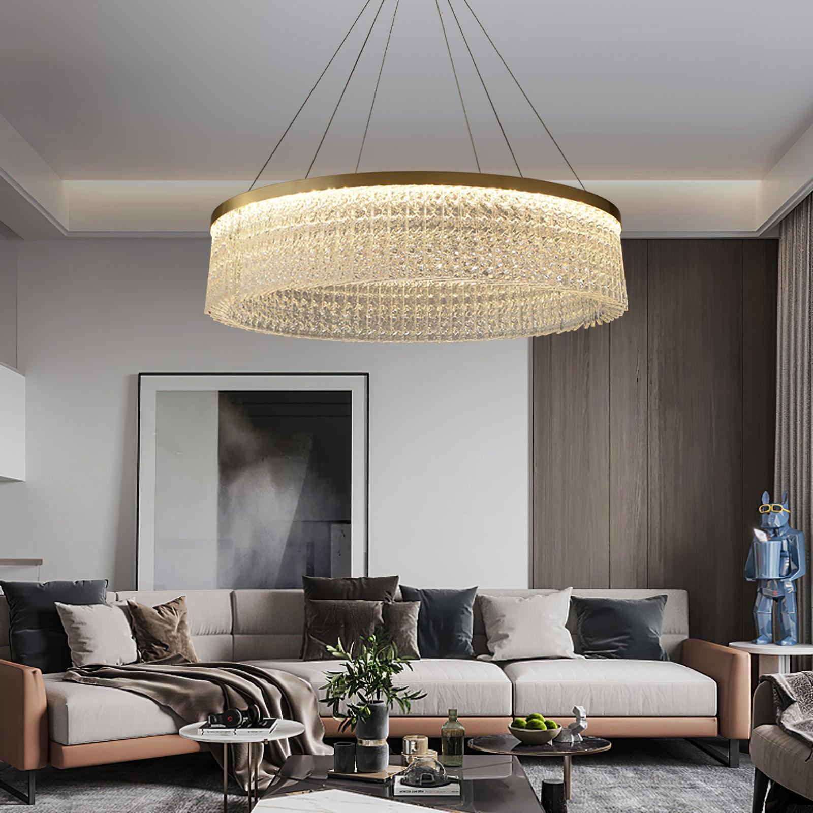 Large crystal ring above pale sofa and dark cushions, grouped round tables, grey artwork and blue decorative figure