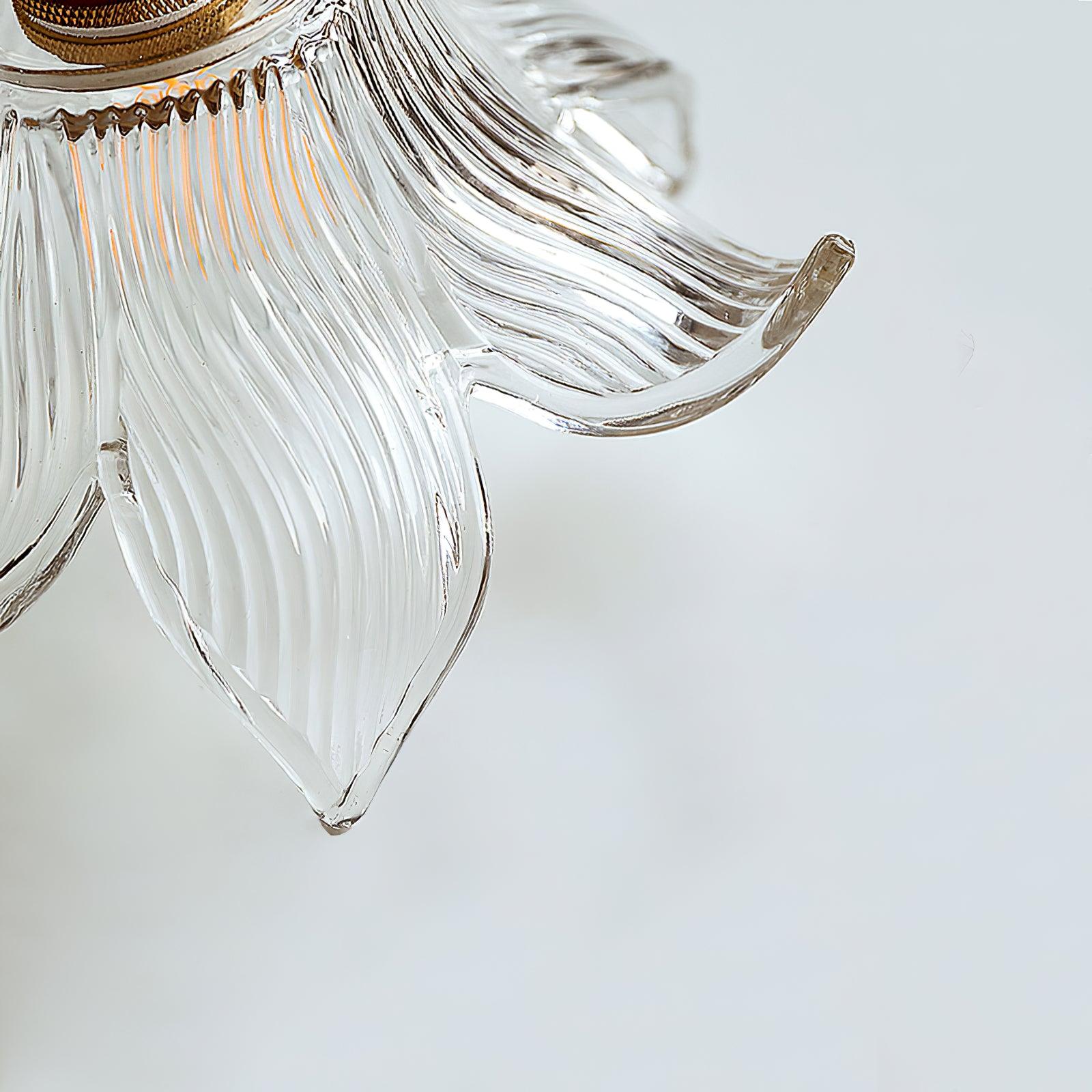 Close pointed glass petal edges and fine curved ribs, with part of the knurled brass-toned holder on white.