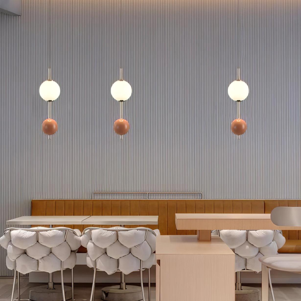 Three separate two-ball pendants arranged above a table