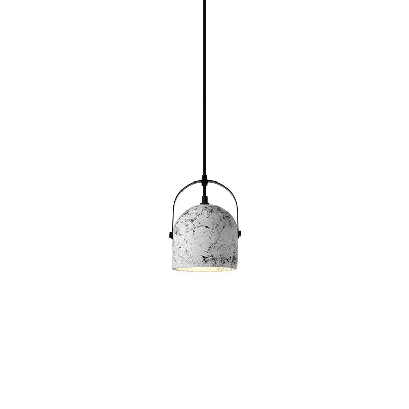 White patterned cement shade suspended within a black arched frame