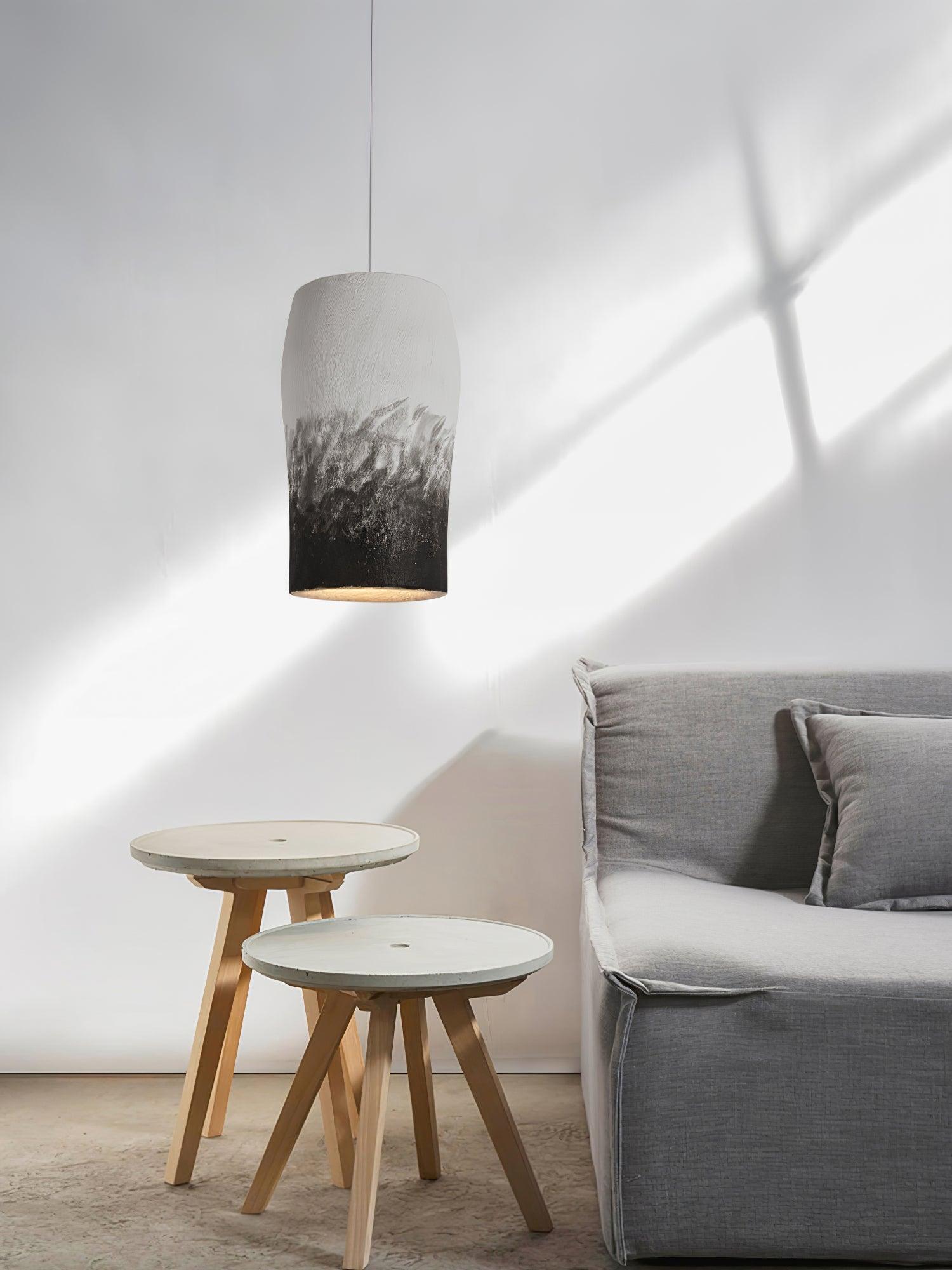 Tall pendant shade near a sofa and small tables