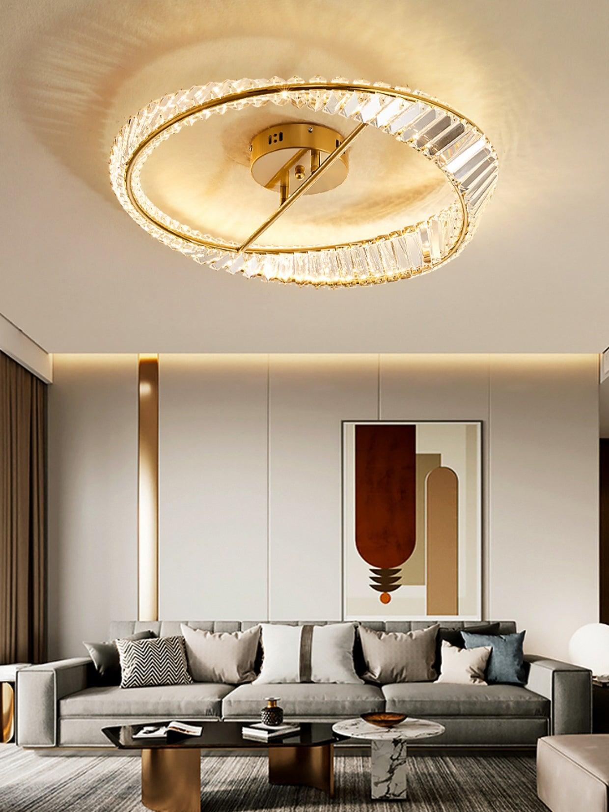 Gold-tone glass ring light above a grey sofa, black coffee table and abstract wall print