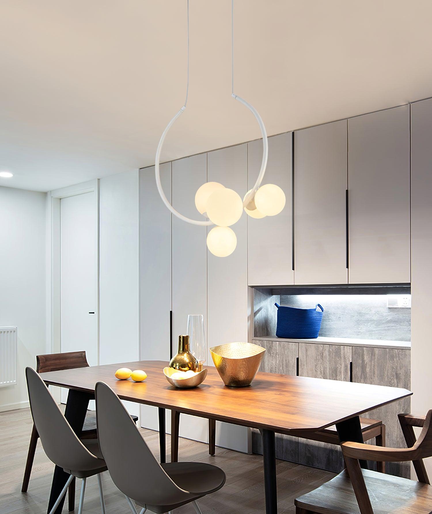 White pendant with glowing globes over a dining table